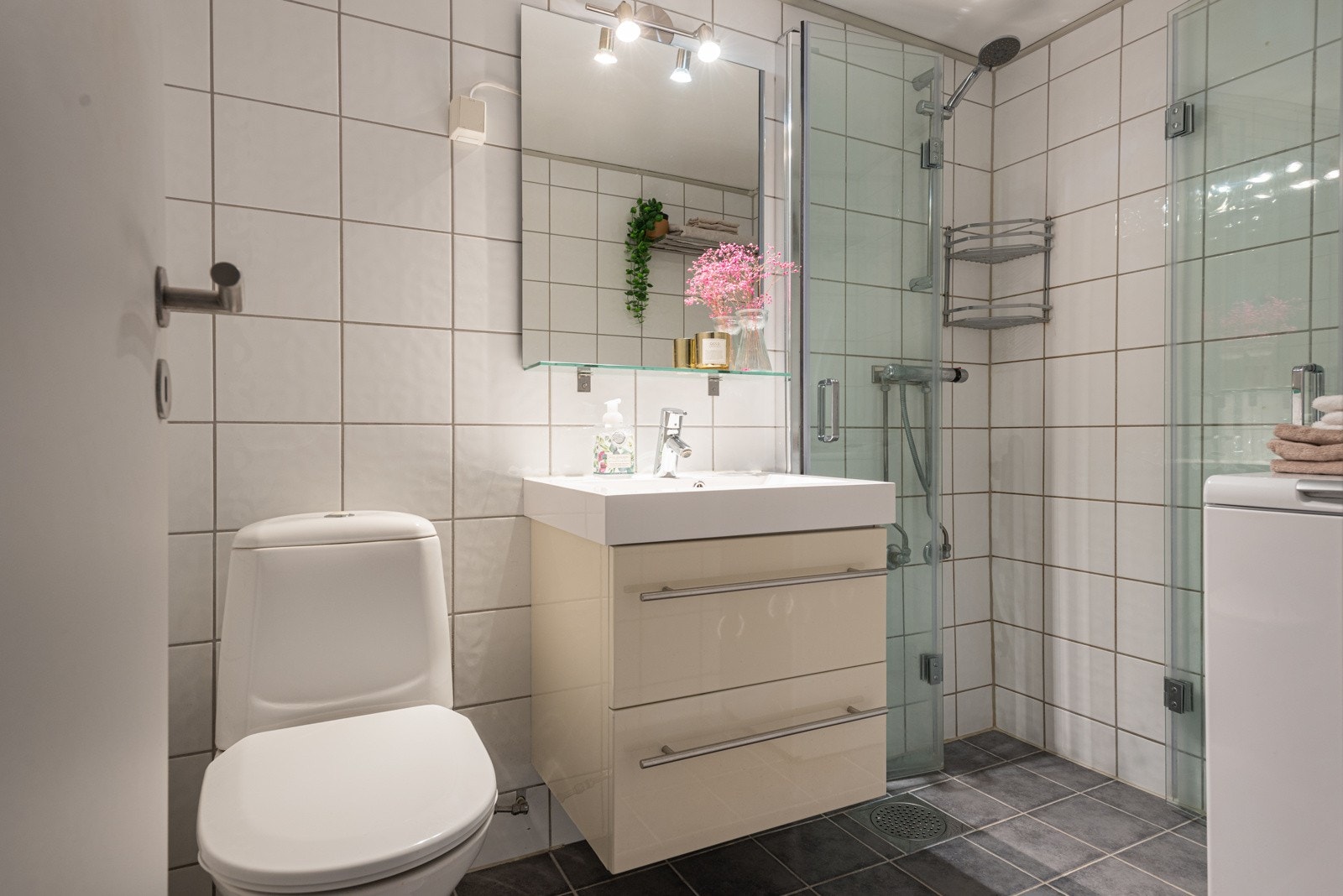 Leiligheten har et delikat bad med flislagte overflater og downlights i himling Galleribilde