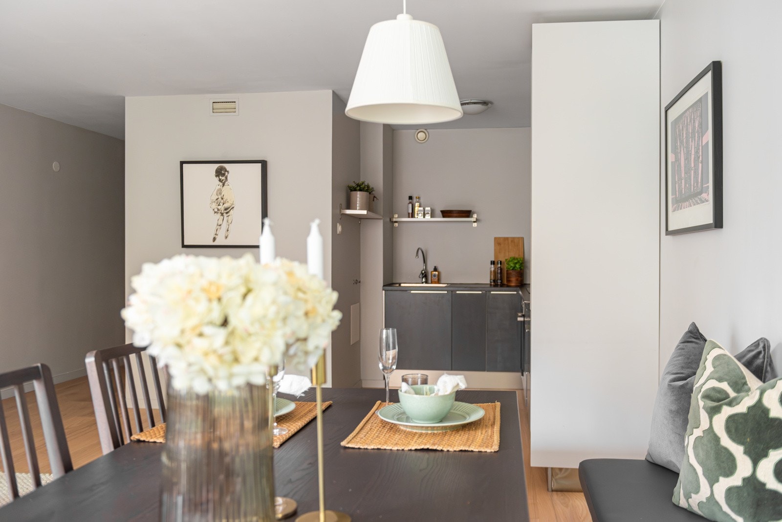 Kjøkkenet ligger i egen nisje og innredning har glatte, malte fronter med laminat benkeplate Galleribilde