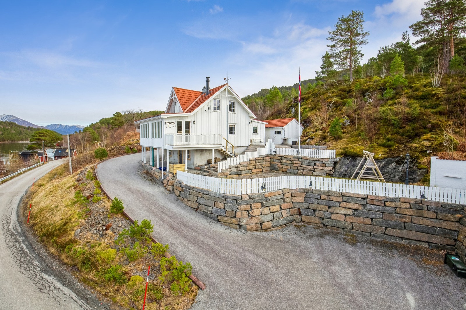 Natursteins trapp og etablert ulike nivåer på tomten. Asfaltert innkjørsel og parkering. Galleribilde
