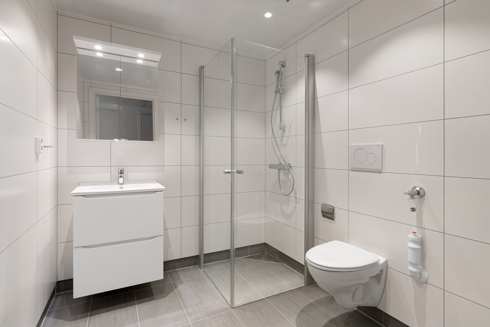 Pent flislagt baderom med downlights i himling og varme i gulv.