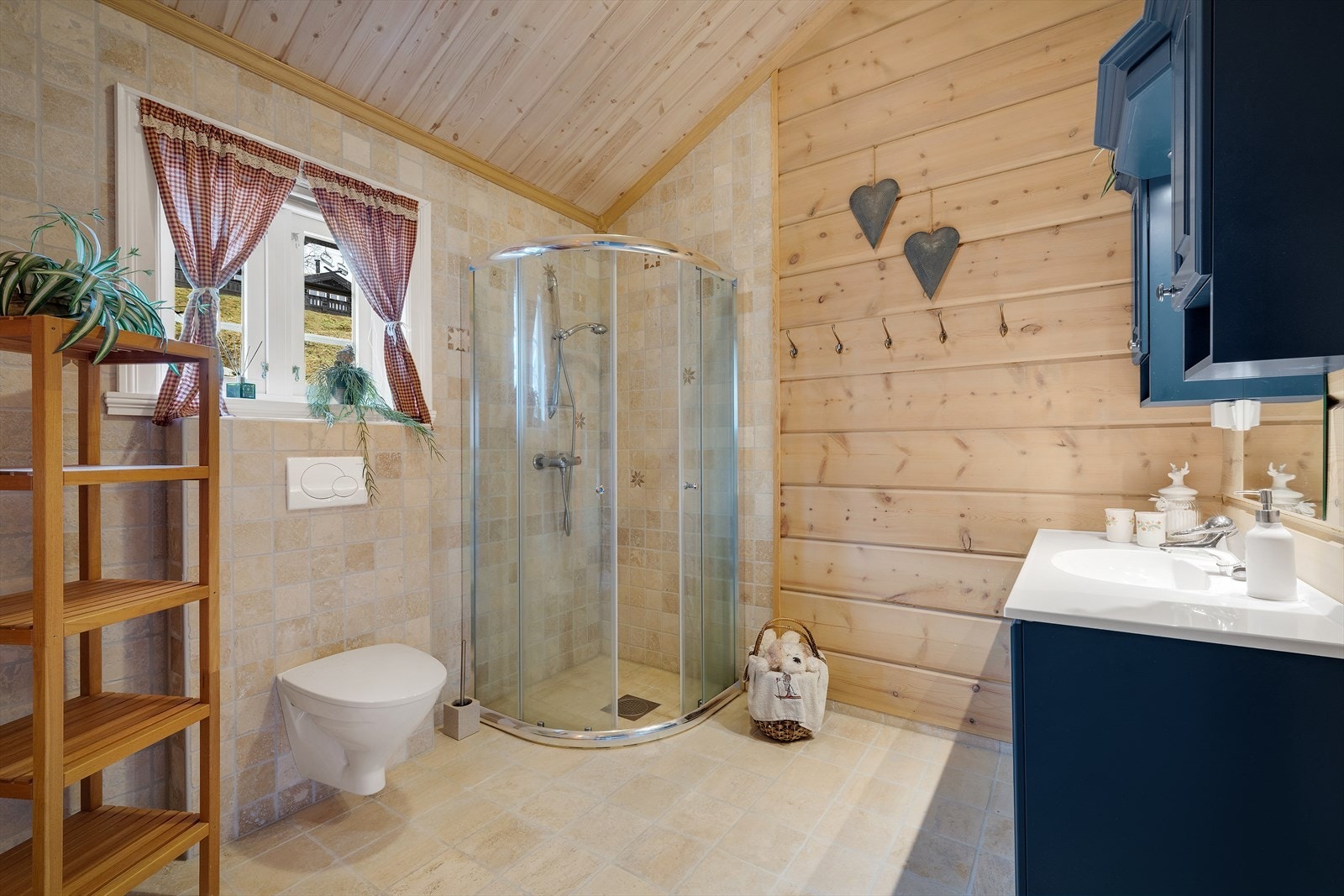 I enden av gangen ligger badet, som er lyst og pent med fliser på gulv og deler av vegg Galleribilde