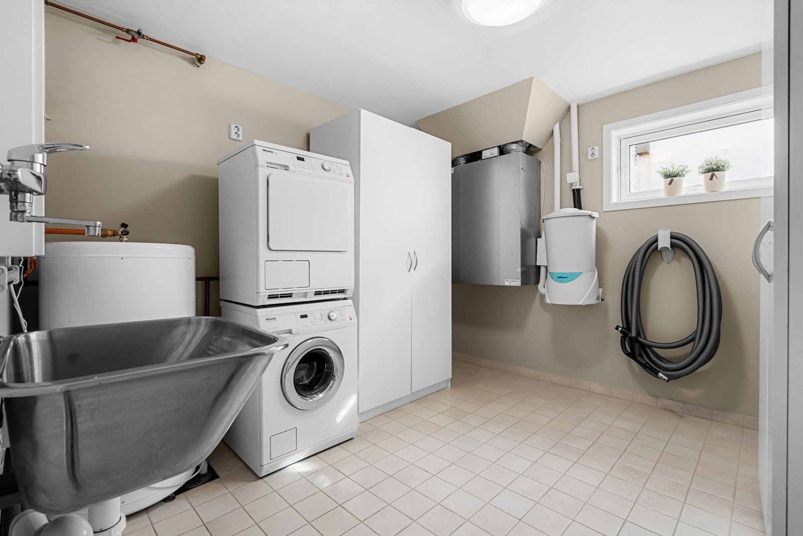 Huset er svært innholdsrikt og har også et stort og praktisk vaskerom. Rommet har vaskekum, opplegg for vaskemaskin og balansert ventilasjon. Varmtvannstanken på ca. 200 liter er plassert her. Galleribilde