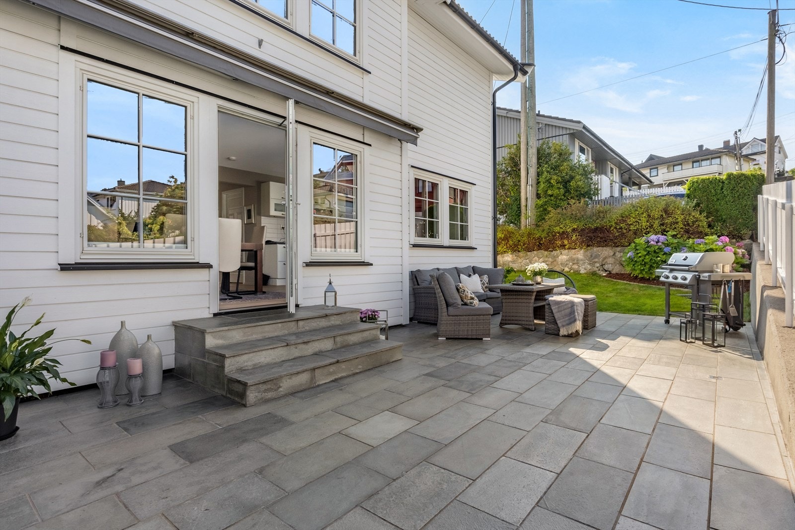 Fra spisestuen har du direkte tilgang til en fin skiferbelagt uteplass på ca. 38 m², ideell for utendørs måltider og for å forlenge sommerkveldene i hyggelige og rolige omgivelser. Galleribilde
