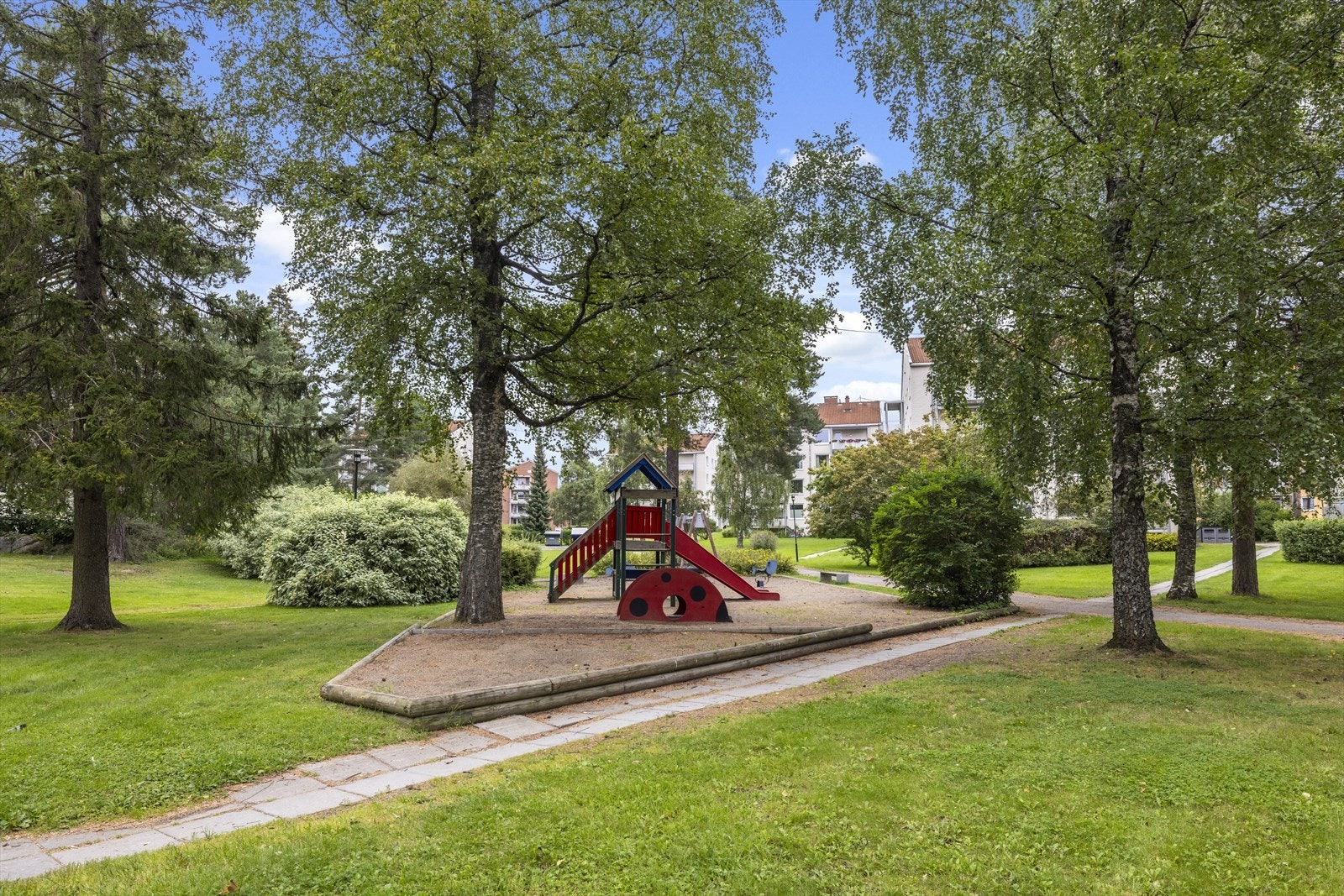 Pent opparbeidet fellesarealer med sittebenker og lekeplass. Galleribilde