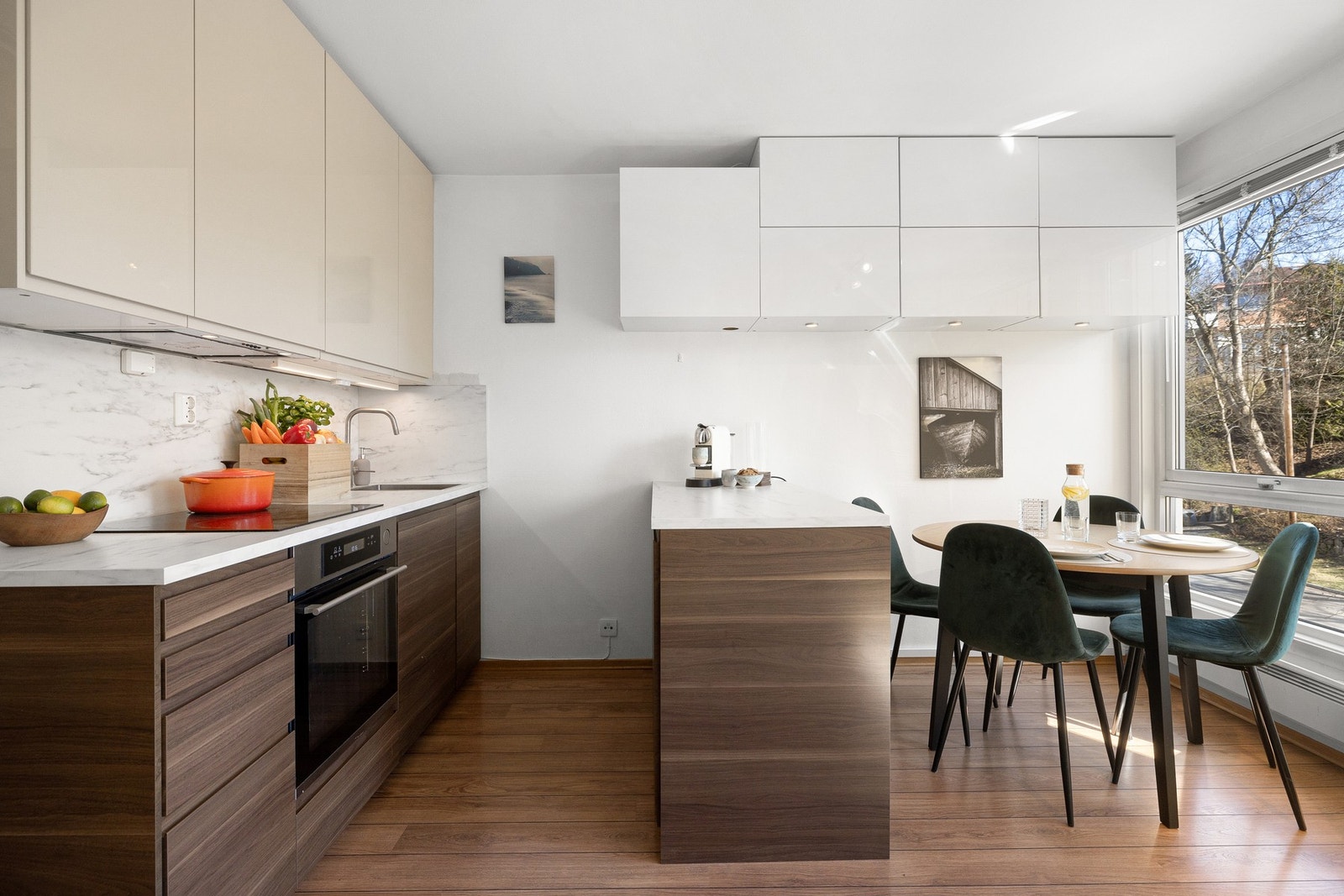 Kjøkkenet har en moderne og stilren utforming med glatte fronter og en åpen løsning mot stuen, noe som skaper en sosial og romslig atmosfære. Galleribilde