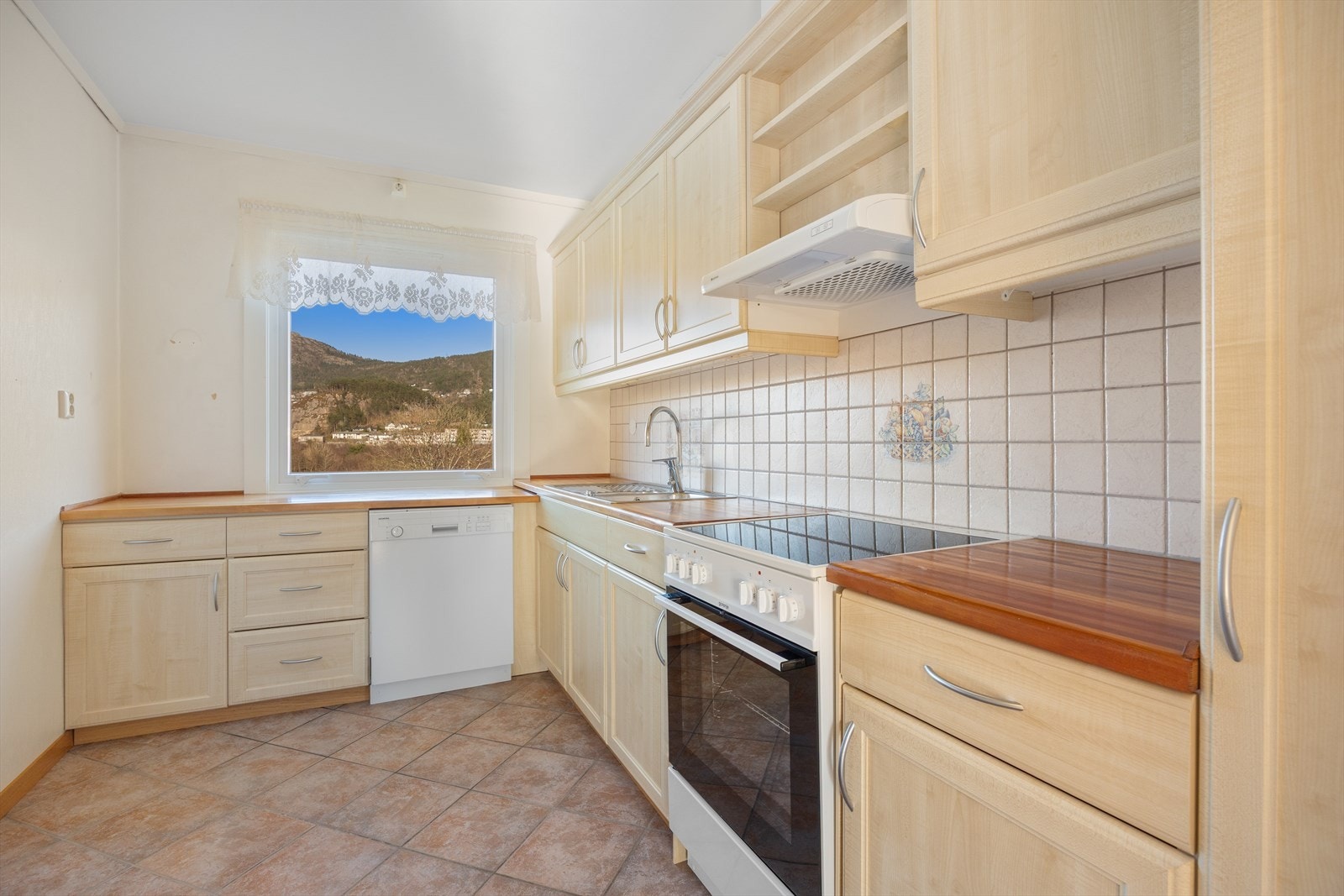 Kjøkkenet har innredning med profilerte fronter. Benkeplaten er av laminat. Galleribilde