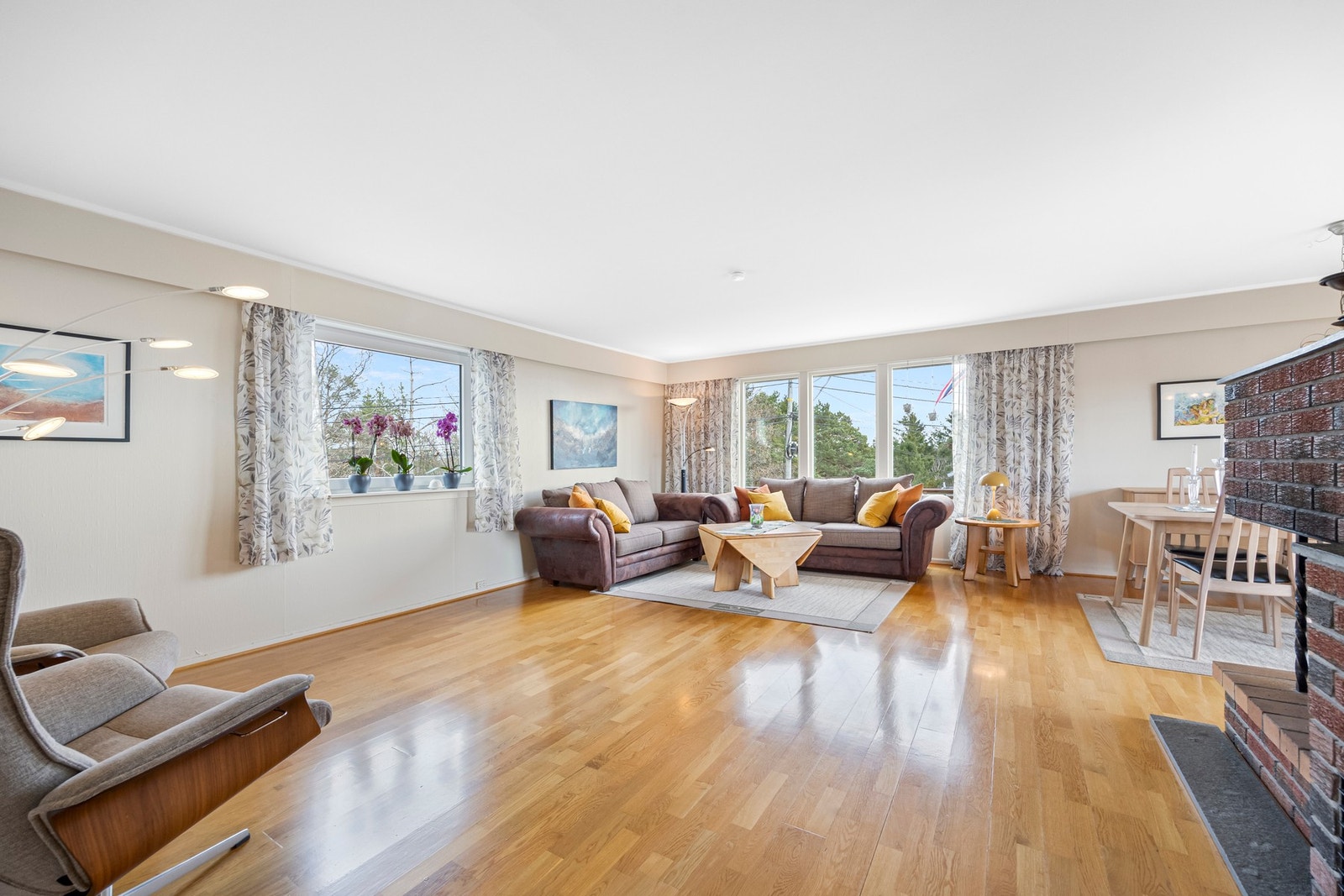 Stor og lys stue med vinduer på tre sider - Rikelig med plass til flere sittegrupper Galleribilde