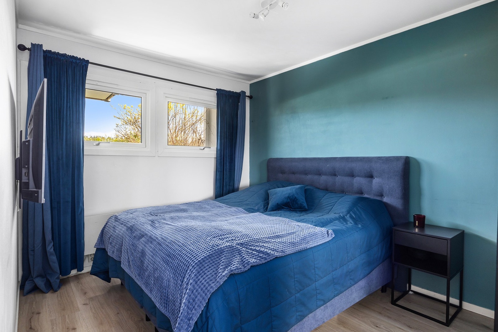 Boligens soverom er av fin størrelse og byr på plass til dobbeltseng med tilhørende nattbord. Galleribilde