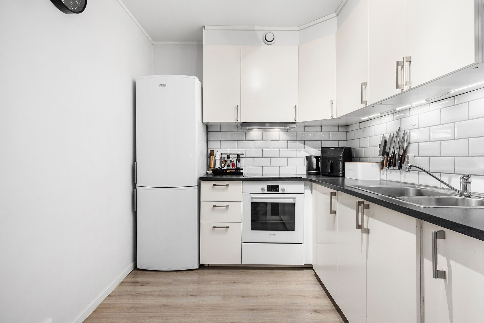 Boligen har et delvis tilbaketrukket kjøkken fra 2015. Lys innredning med glatte fronter, laminat benkeplate og nedsenket oppvaskkum med ett-greps armatur. Galleribilde