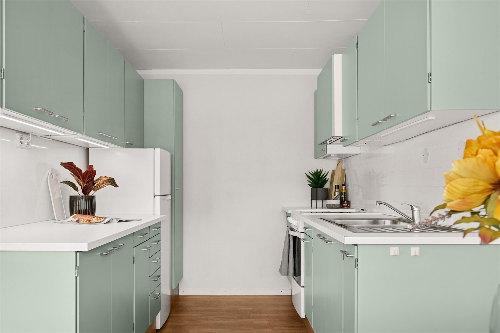 Boligens kjøkken har parkett på gulv og malte plater på vegger Galleribilde