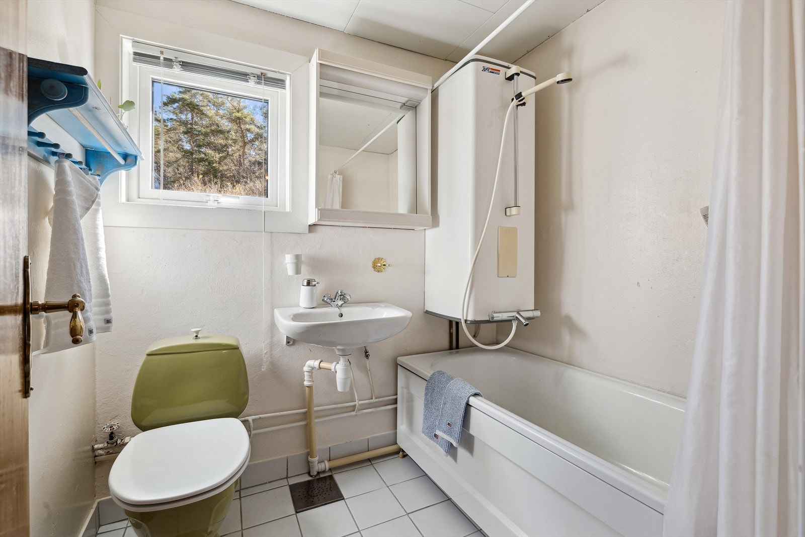 Baderom med enkel standard, servant, badekar varmekabler på gulv. Galleribilde