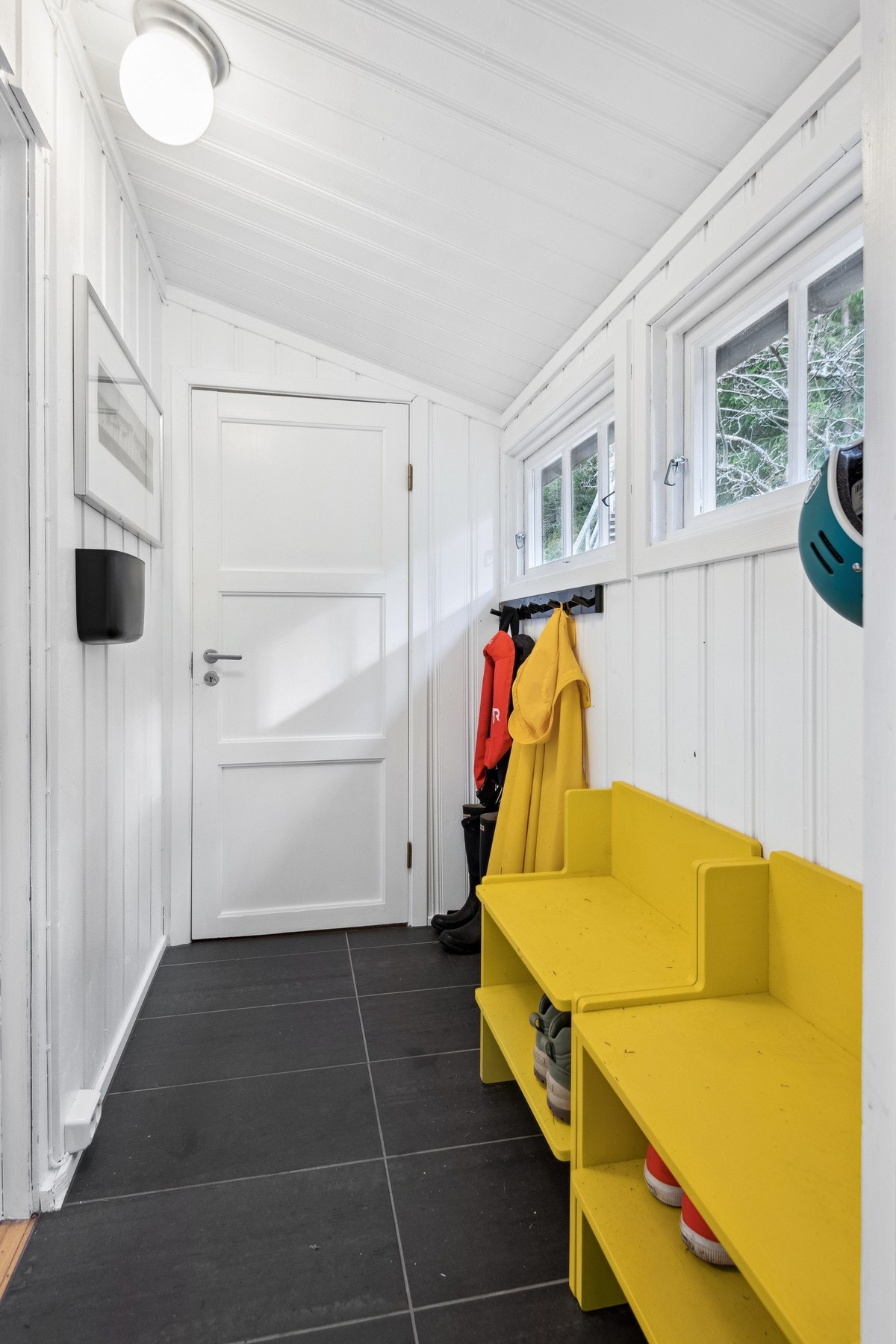 Flislagt gang med opplegg for å henge fra seg jakker og sette sko. Galleribilde