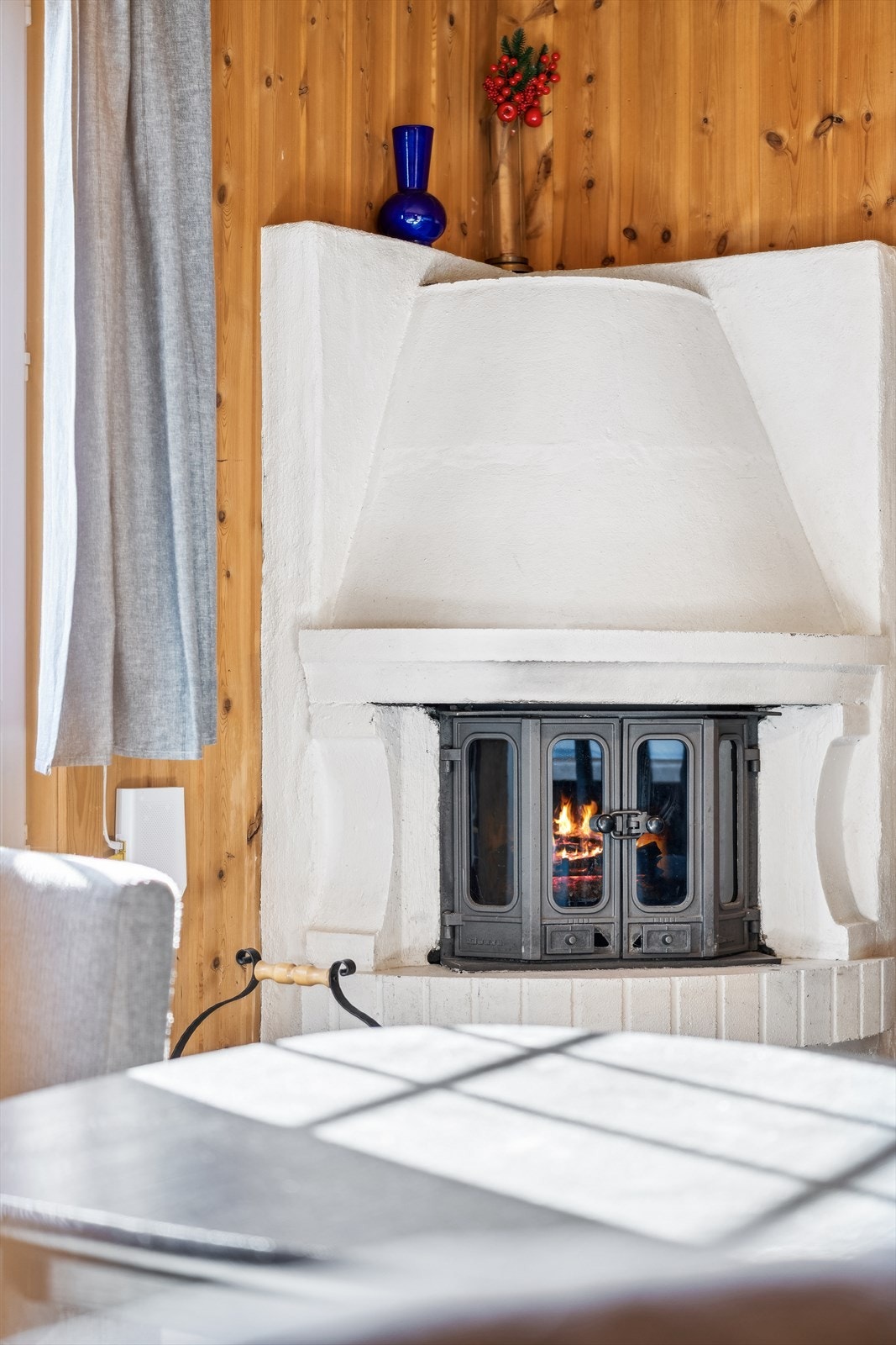 Detalj av peisen som gir stemningsfull og deilig varme på kalde dager og sene kvelder. Galleribilde