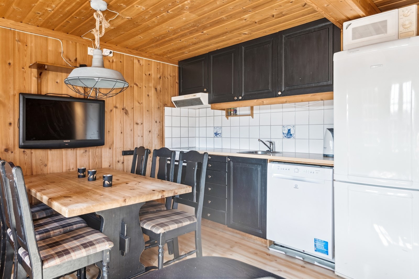 Spiseplassen med kjøkkenet, som har profilerte fronter og skuffer i tre, fliser mellom overskap og benkeplate, og laminerte benkeplater med nedfelt oppvaskkum. Galleribilde