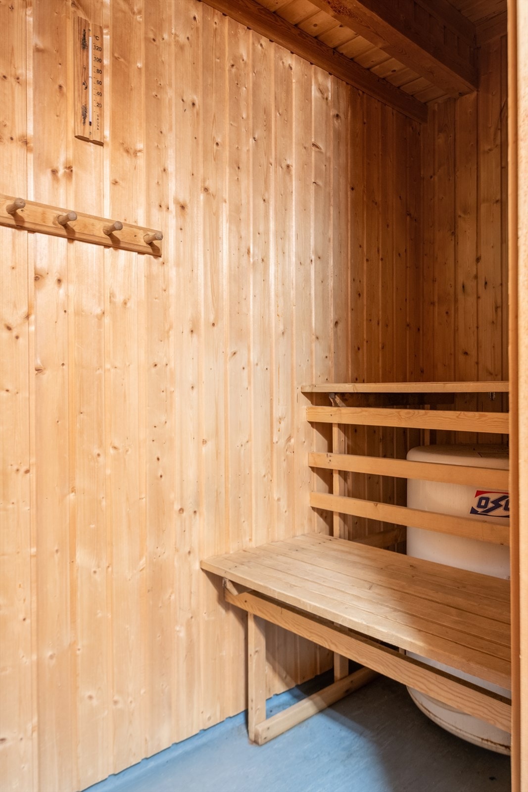 Badstue med Tylö badstueovn og naturlig ventilasjon. Sittebenker i tre og knagger for oppheng. Badstuedør i tre og vv-bereder er plassert under sittebenk. Galleribilde