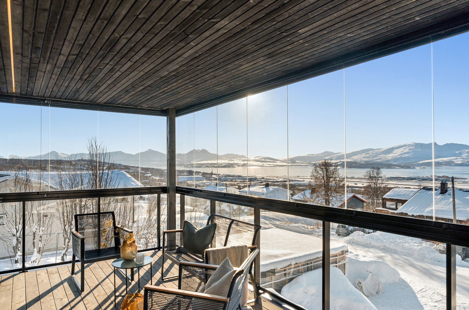 En stor innglasset balkong med utgang fra stuen - vender mot sør og vest med panoramautsikt over fjorden.