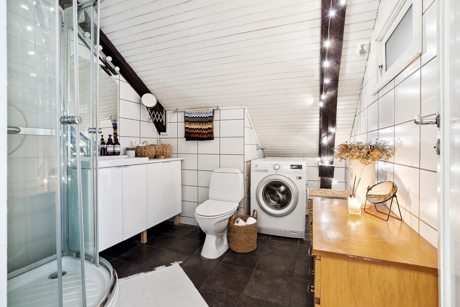 Badet er flislagt både på gulv og vegger, med en fin malt himling som gir et helhetlig og stilrent inntrykk. Galleribilde