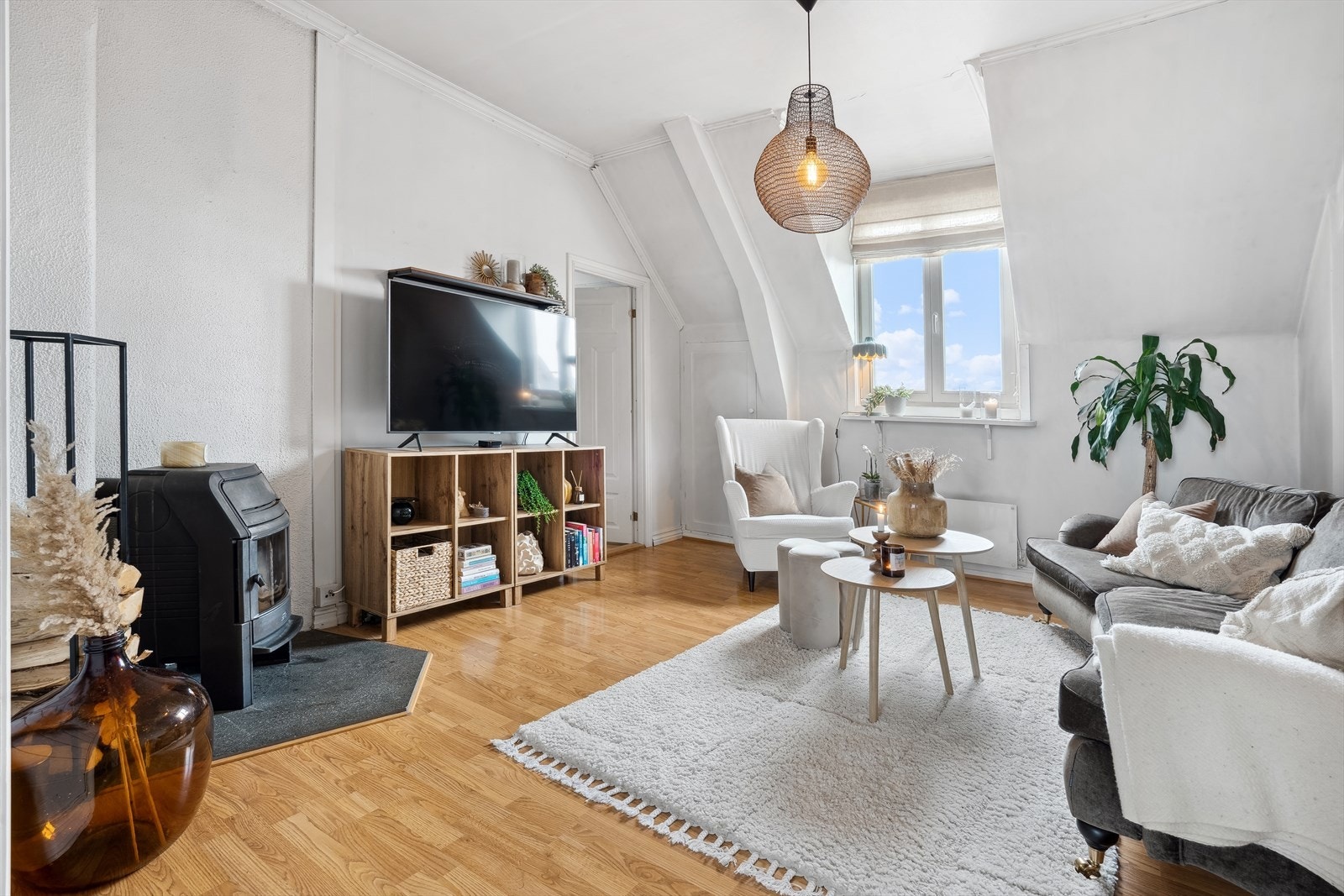 Stuen imponerer med høy takhøyde og synlige bærebjelker. Galleribilde