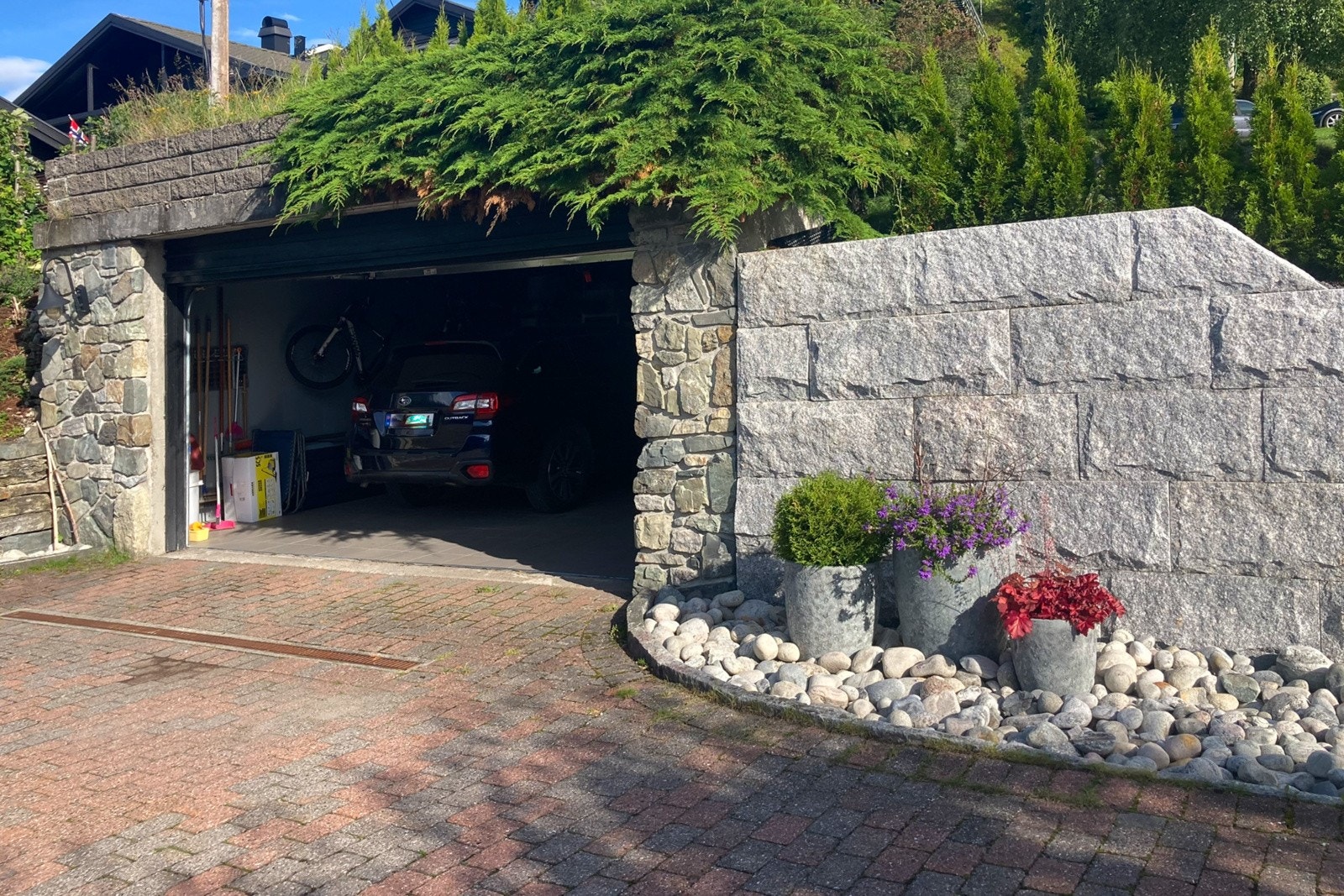 Det er parkering i en dobbelgarasje, carport og på en steinbelagt gårdsplass. Galleribilde