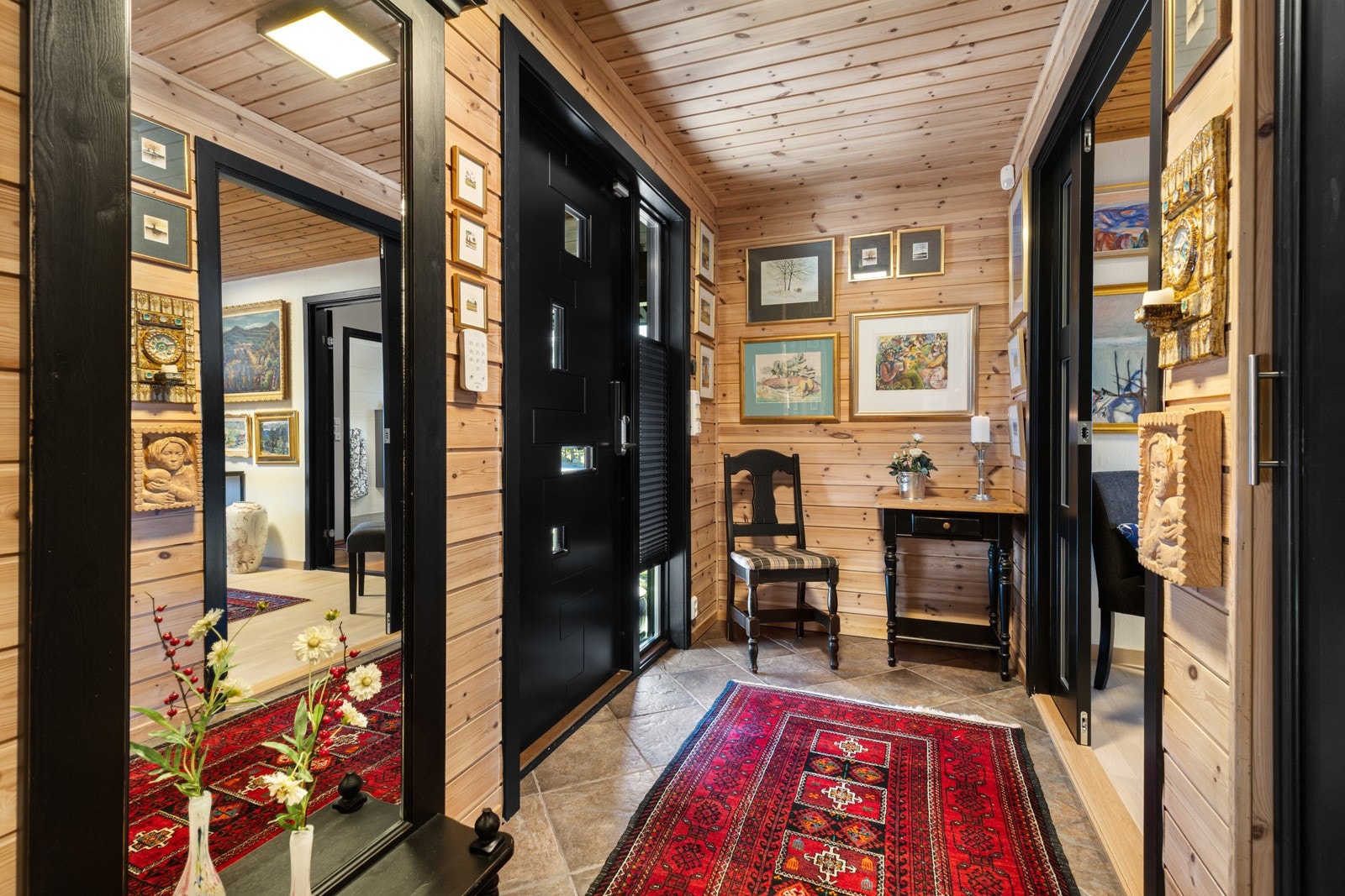 Vel inne blir vi ønsket velkommen i en fin entré med naturlig panel på veggene og fliser på gulv med gulvvarme. Galleribilde