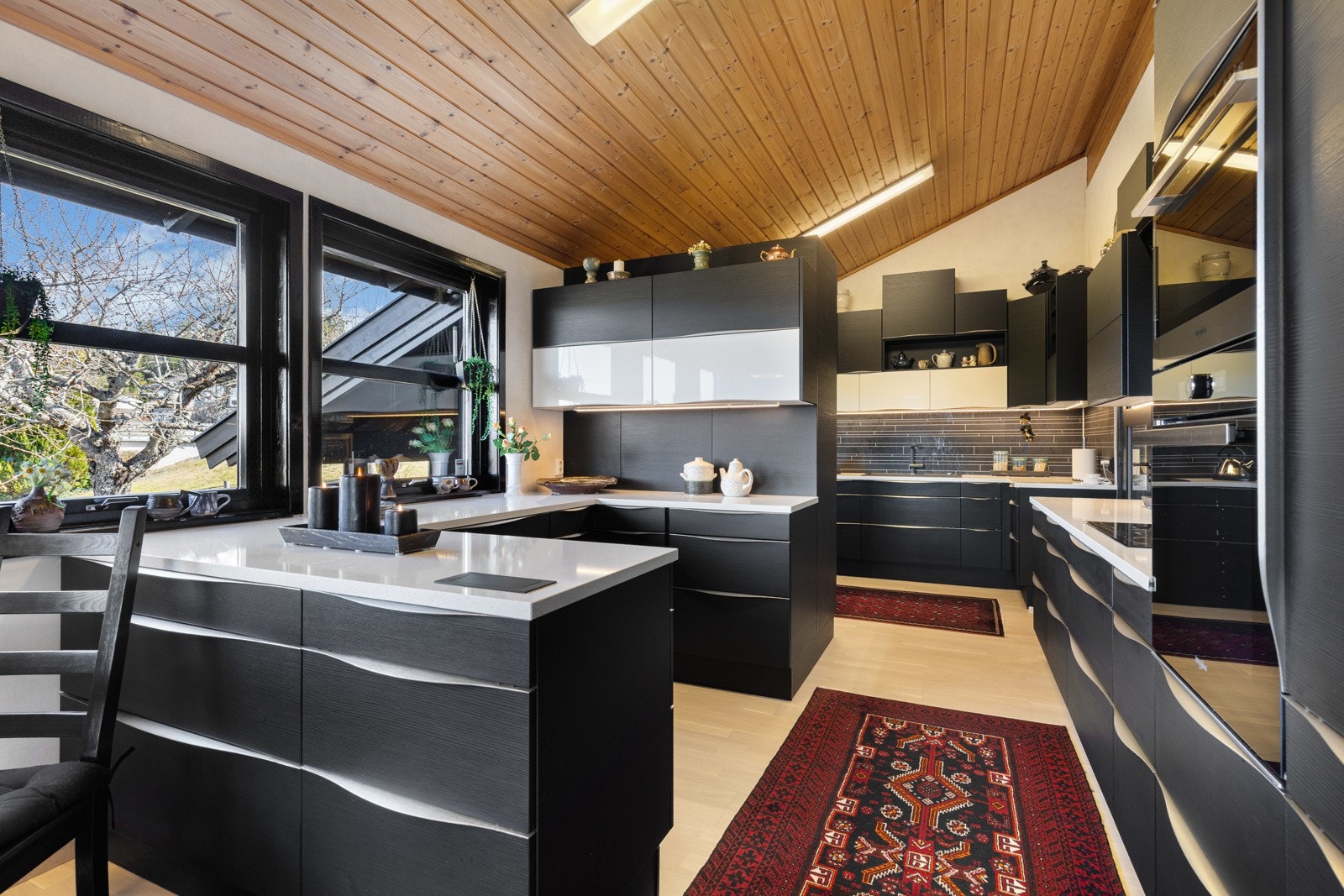 Innredningen fra Aubo har sorte, glatte fronter og hvit benkeplate i kompositt med nedfelt, sort kum. Galleribilde