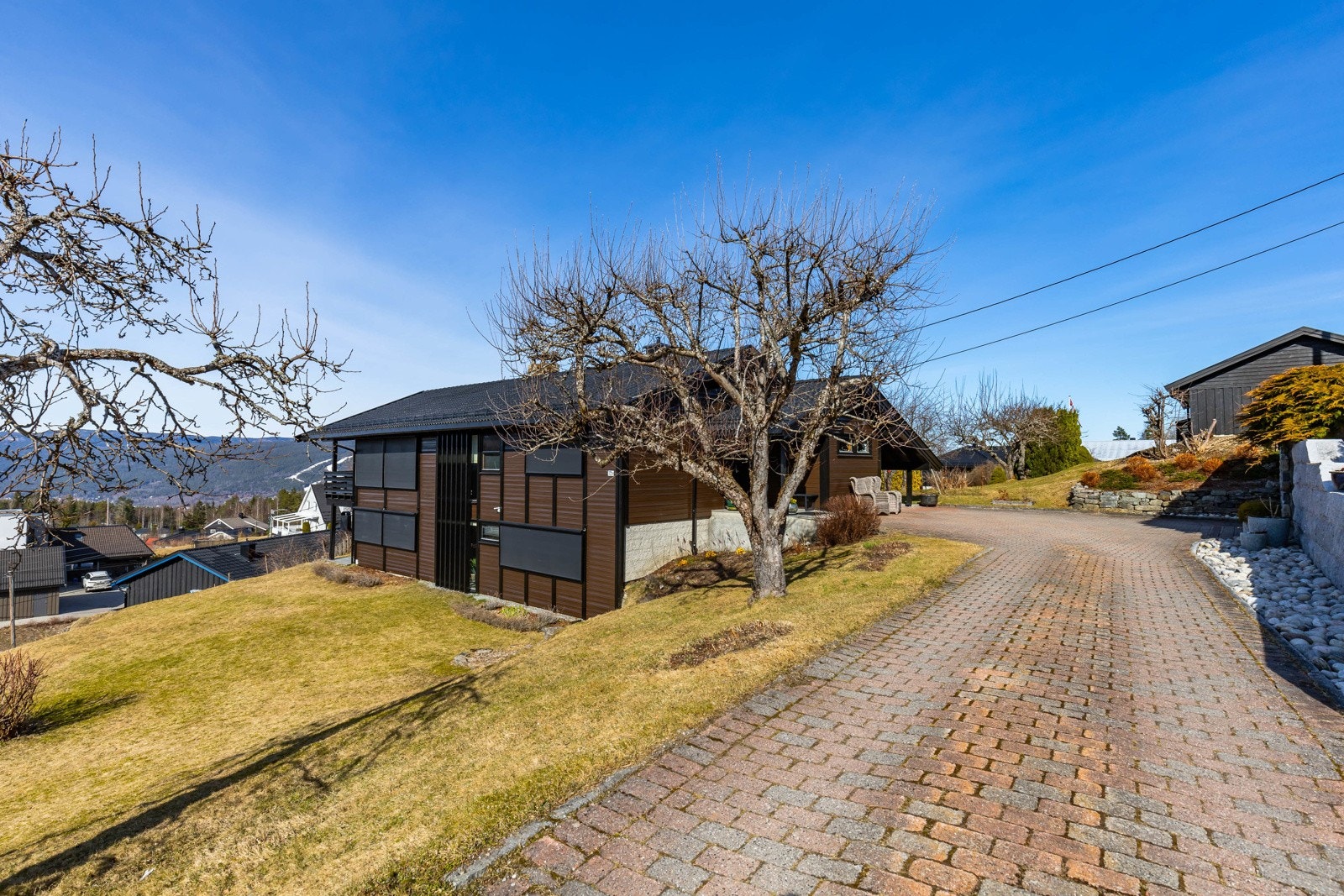 Videre kan eiendommen stolt skilte med en stor, solrik hage med frukttrær og bærbusker, to solrike uteplasser med vidstrakt utsikt, steinbelagt gårdsplass og stor garasje. Galleribilde