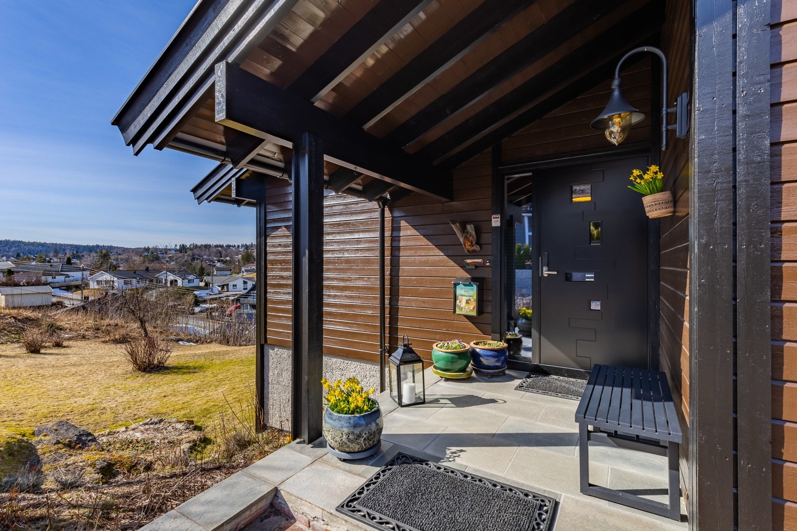 Eneboligen har et pent, overbygd inngangsparti med steinbelagt adkomst, skiferlagt repos og veggmontert utebelysning. Galleribilde