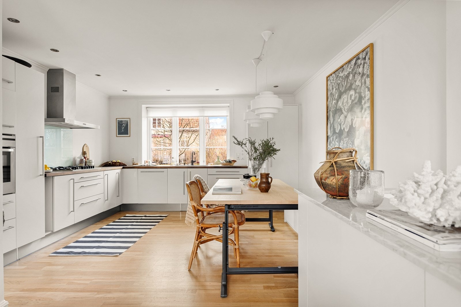 Kjøkkenet ligger i en åpen løsning, men befinner seg samtidig noe skjermet fra resten av stuen. Legg merke til marmorplaten i ved trappeløpet som er fra 2020 fra Allstein. Galleribilde