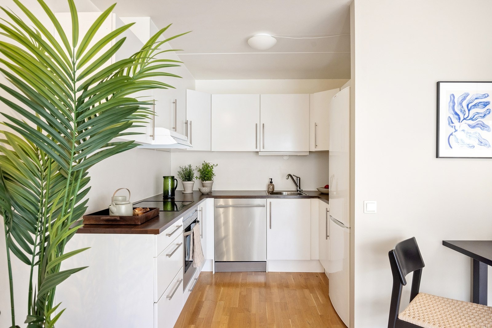 Innredningen er moderne og funksjonell fra Norema, med glatte hvite fronter i laminat og benkeplate i laminat. Hvitevarer medfølger. Galleribilde