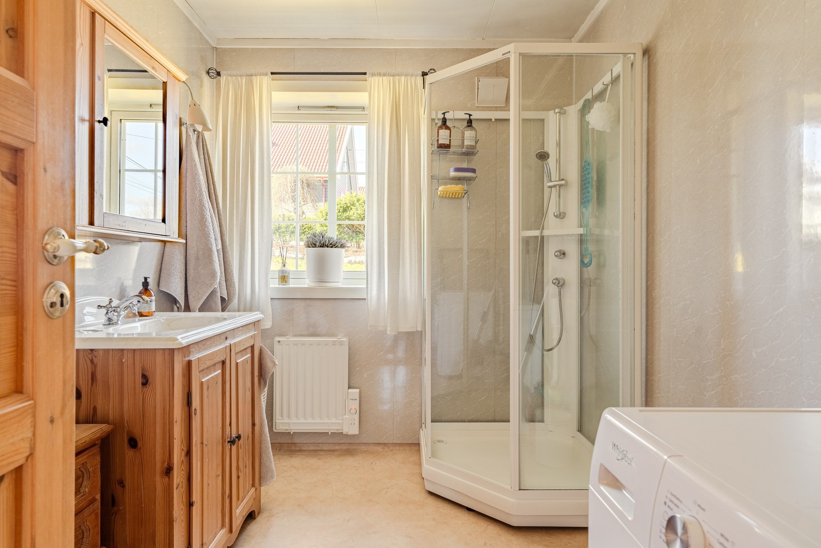 Baderom/vaskerom i 1.etasje er innredet med dusjkabinett, servant og servantskap. Det medfølger avtrekksvifte med fuktsensor som ikke er montert. Galleribilde