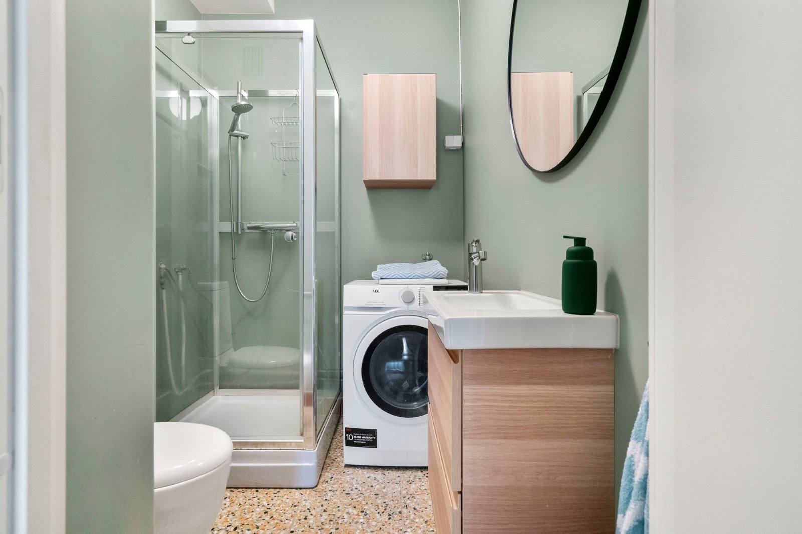 Flott flislagt baderom med gulvvarme og opplegg for vaskemaskin Galleribilde