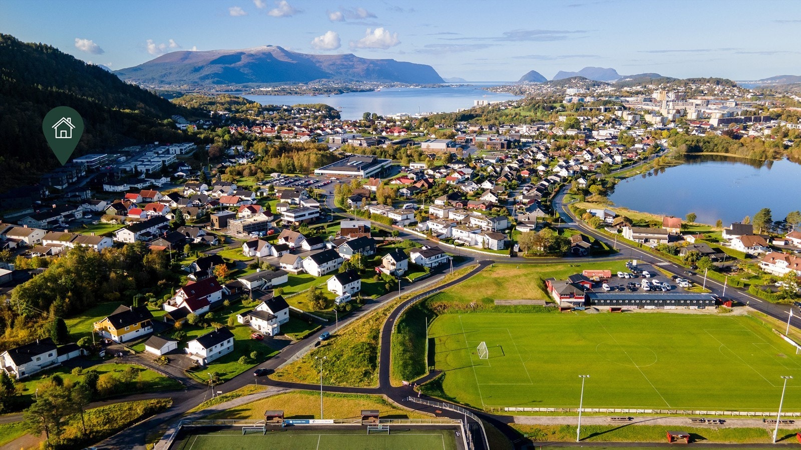 Dronebilde av nærområdet på Vasstranda med Spjelkavik IL sitt anlegg i fremkant og eiendommen beliggende til venstre Galleribilde