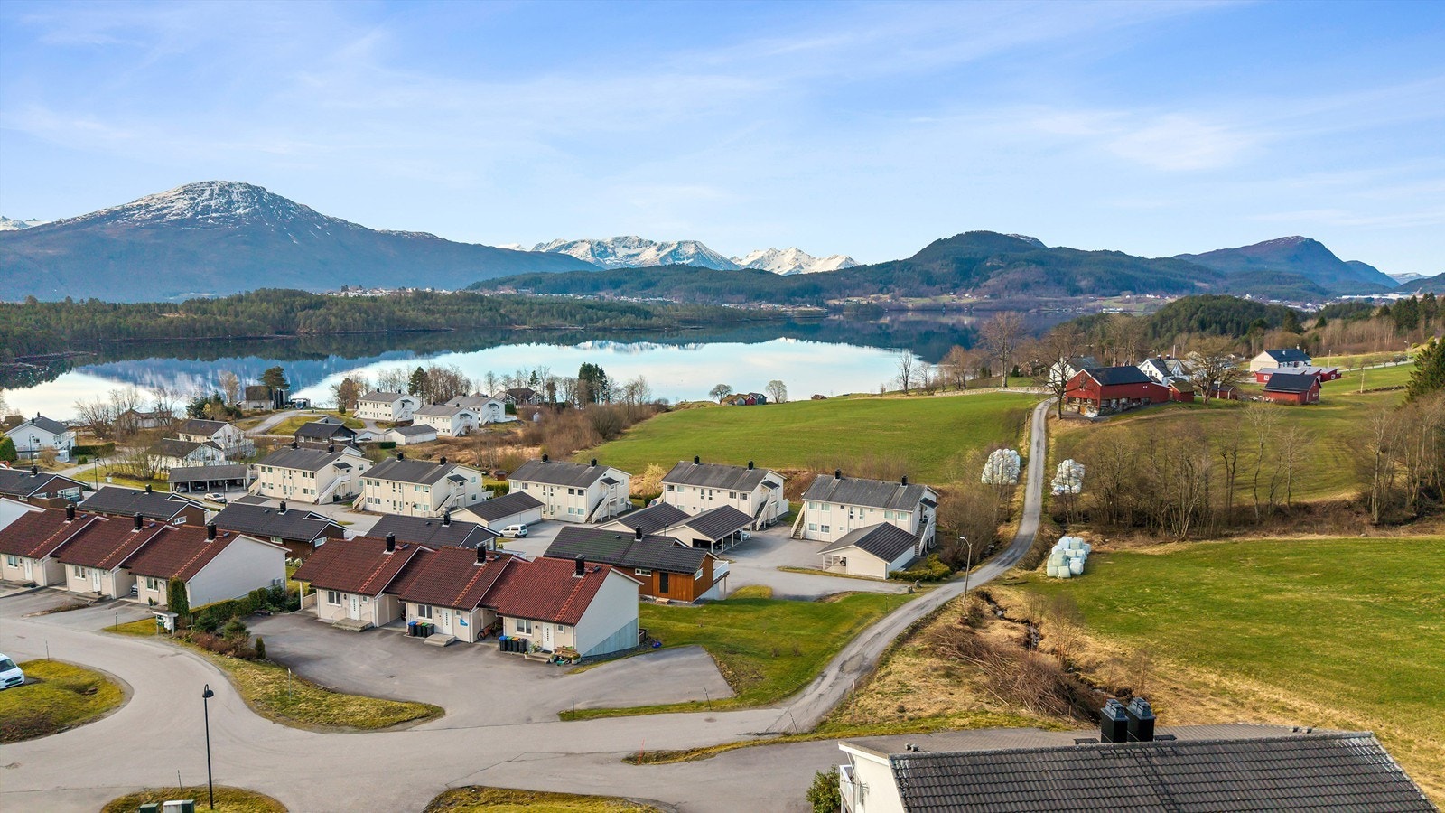 Dronebilde av boligområdet med Skodjevågen og fjella Galleribilde