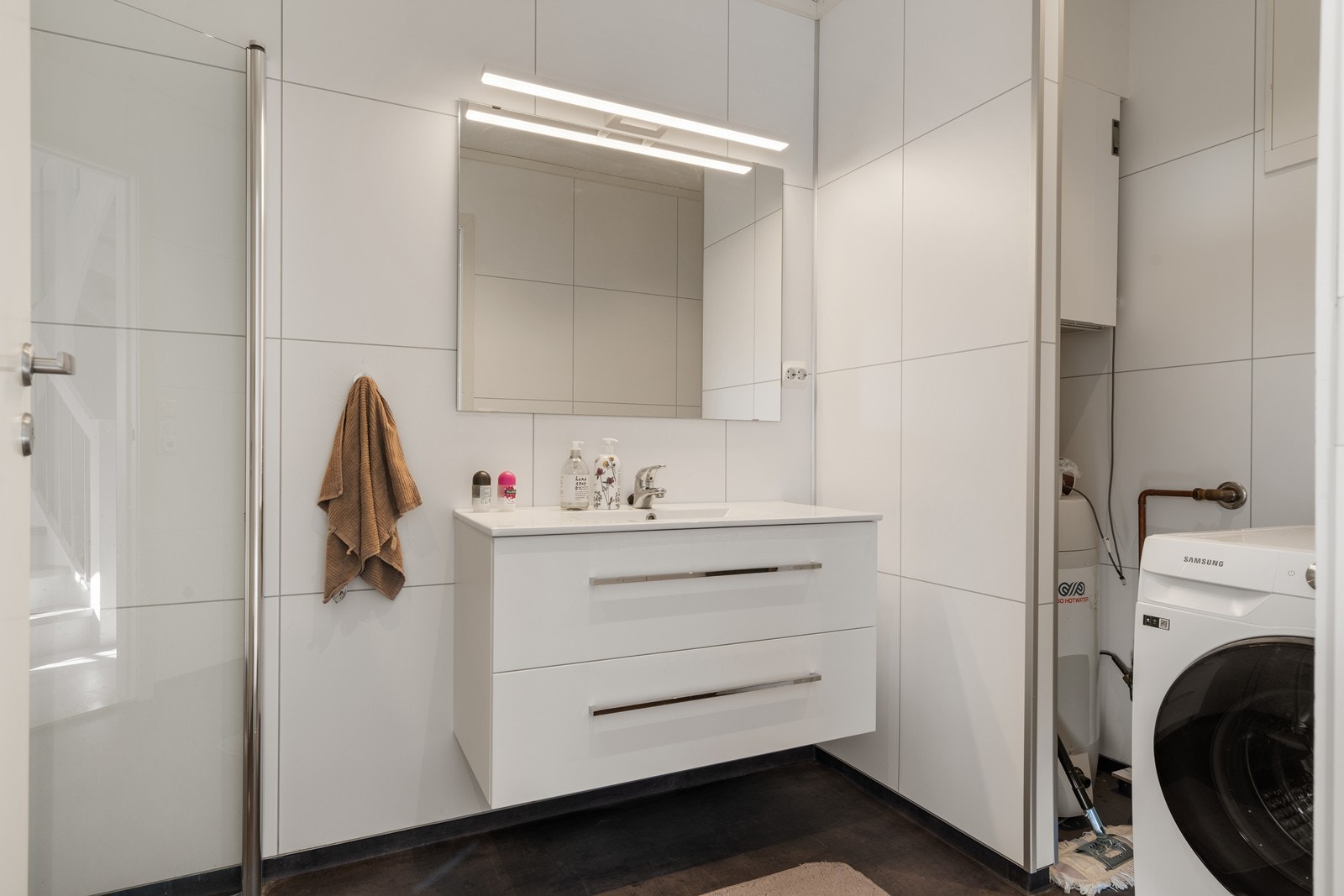 Pent bad/vaskerom med fliser på gulv og våtromsplater på vegger Galleribilde