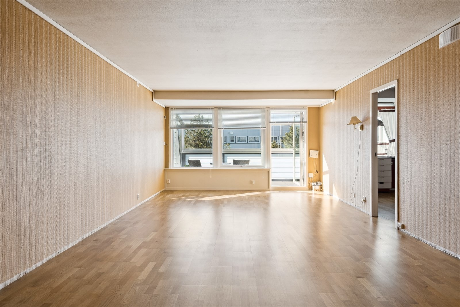 En lys og romslig stue med store vindusflater. Utgang fra stue til innglasset balkong. Galleribilde