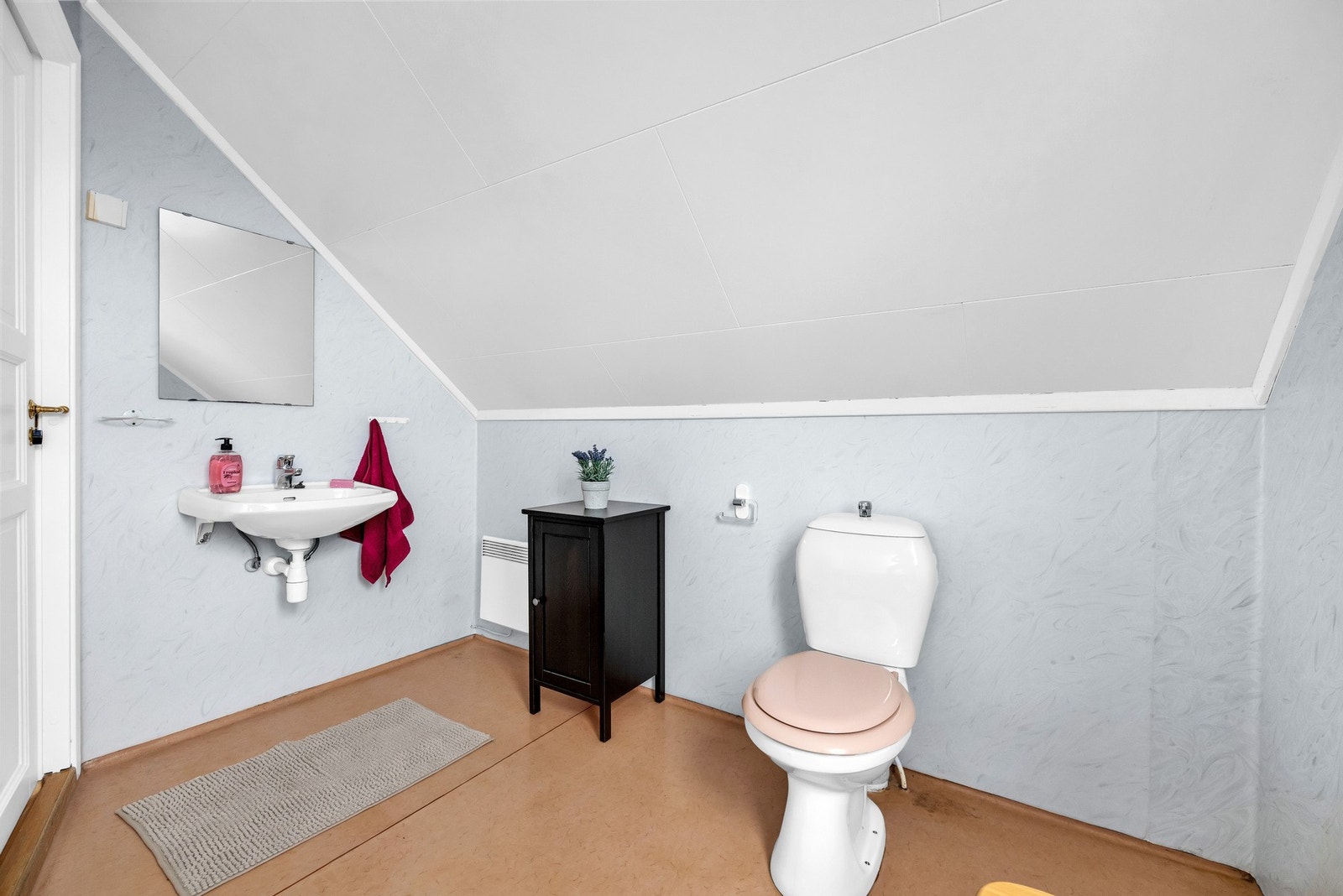 Baderommet er utstyrt med vegghengt servant med ett-greps armatur, badekar med dusjarmatur og gulvmontert toalet. Galleribilde