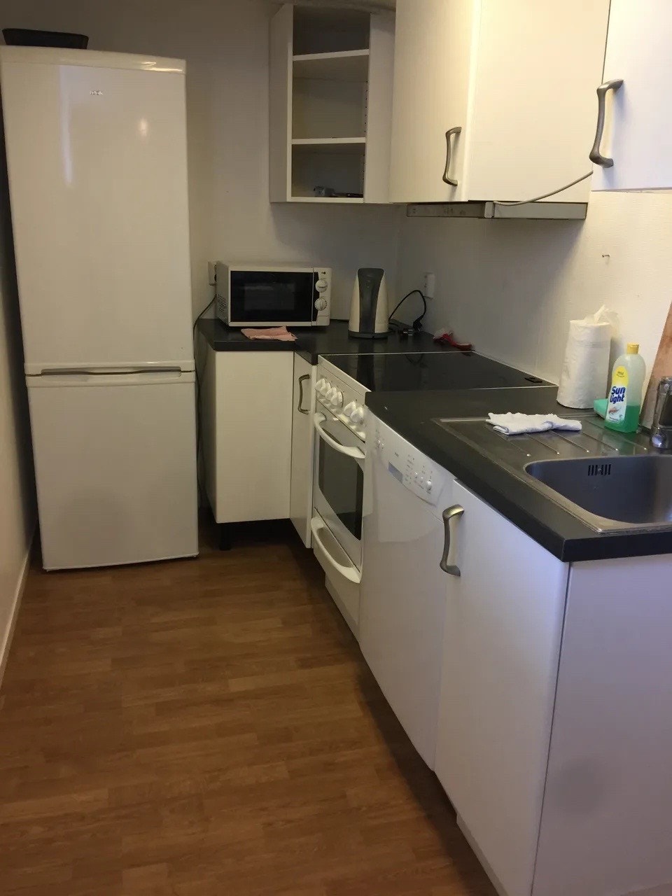 Kjøkken med hvitevarer og oppvaskmaskin. Galleribilde