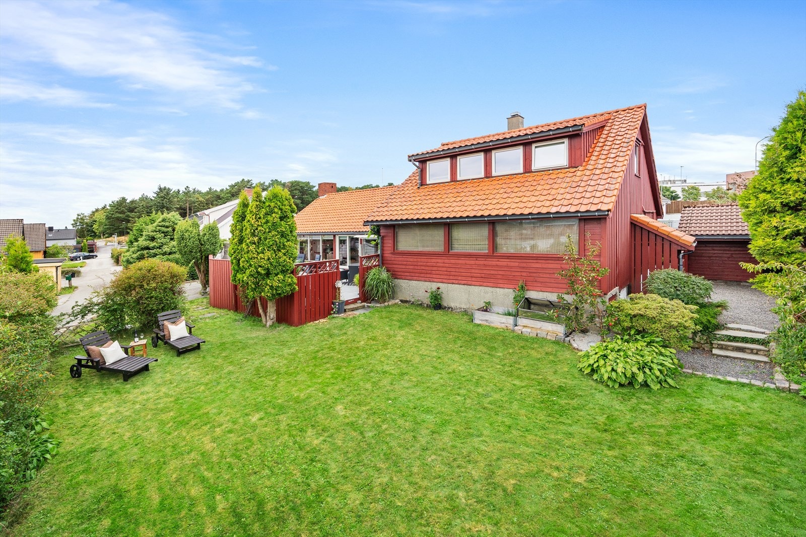 Tomten er pent opparbeidet med hage, asfaltert gårdsplass, samt hekk, busker og trær i tomtegrensen. Galleribilde