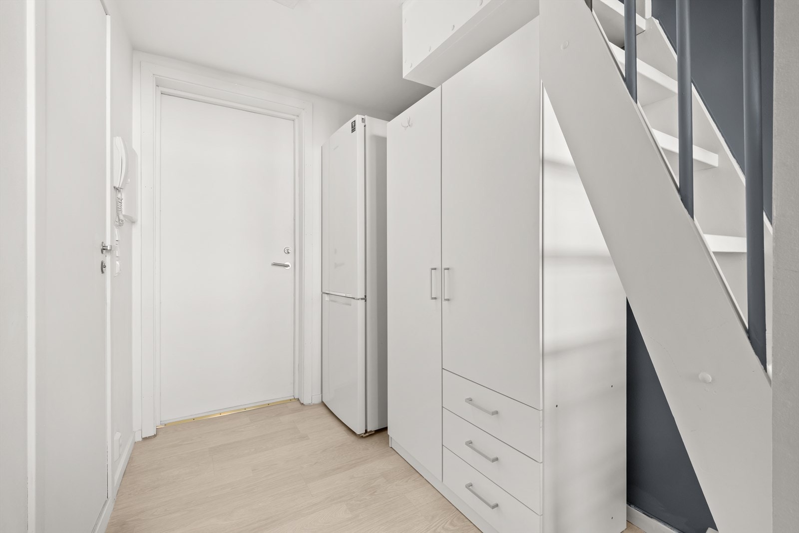 Garderobeskap og frittstående kjøleskap er plassert i gangen Galleribilde