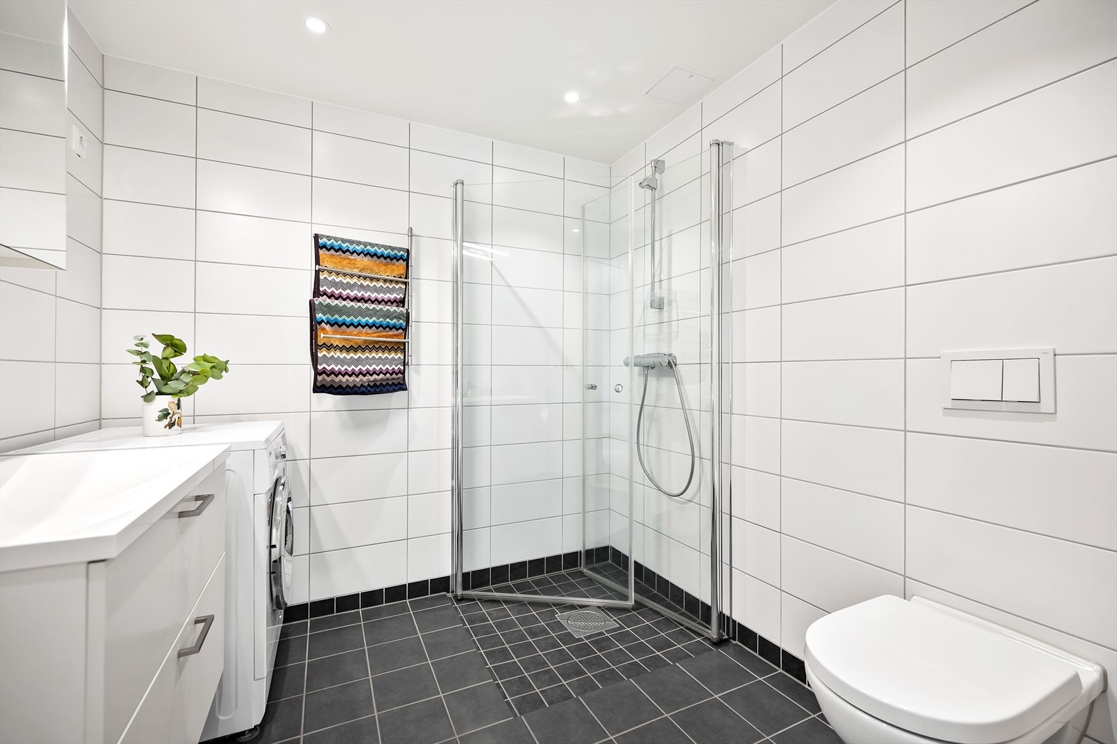 Badet er stilrent med flislagte vegger og gulv, samt elektriske varmekabler som gir en behagelig varme. Galleribilde