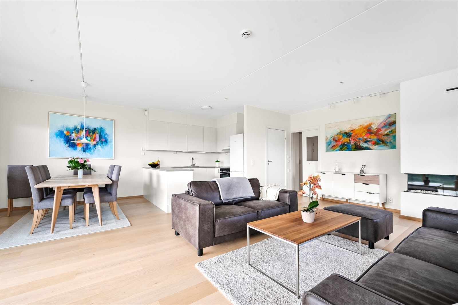 Lys og moderne stue med åpen kjøkkenløsning, ideell for både avslapning og sosiale sammenkomster. Galleribilde