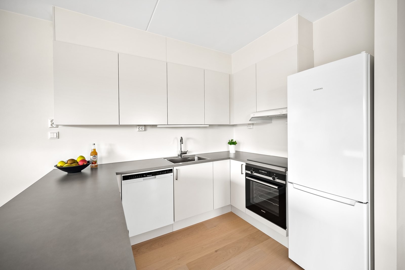 Kjøkkenet er moderne og funksjonelt med glatte fronter og laminat benkeplate. Galleribilde