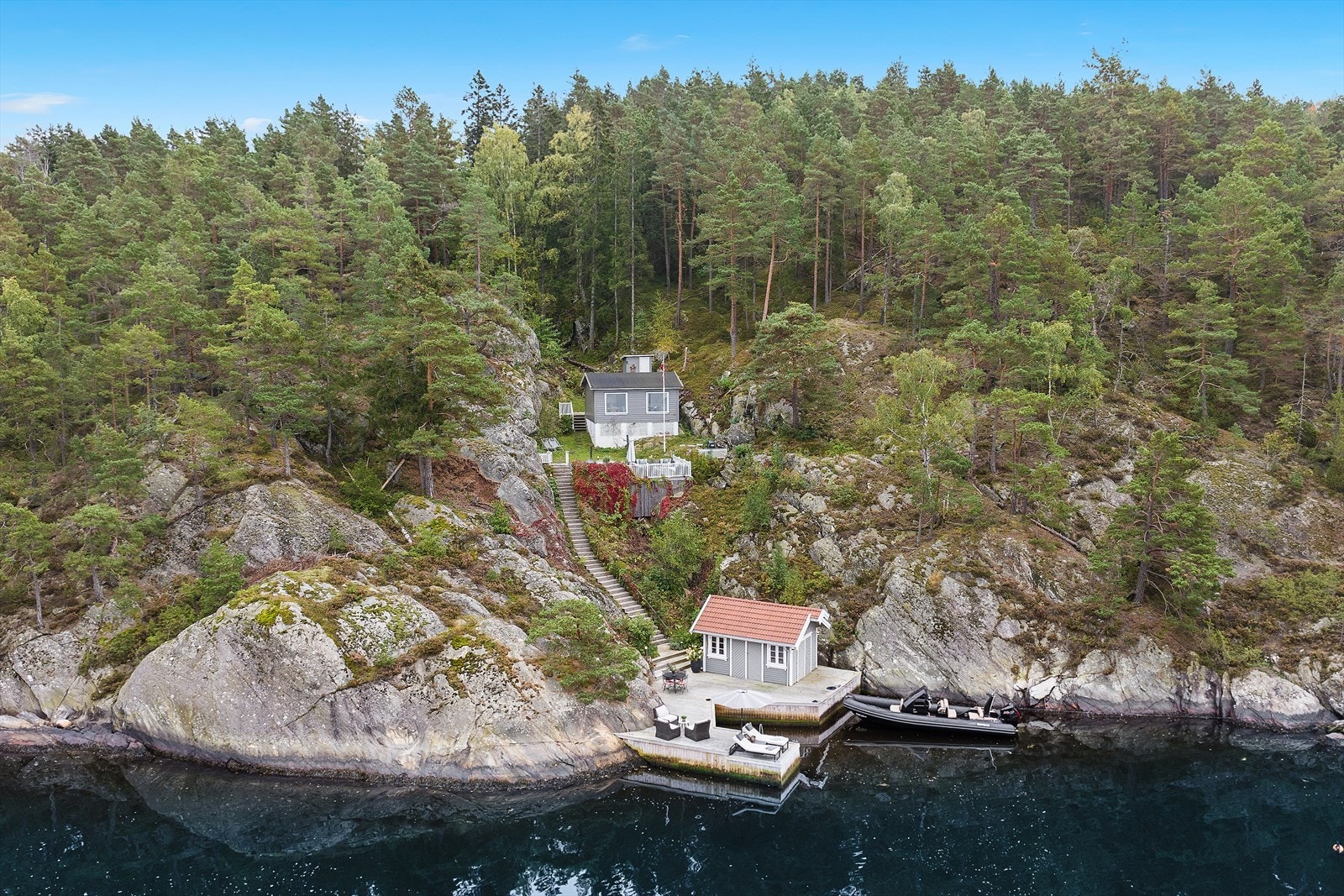 Unik fritidseiendom ved vannet, omringet av skog. Privat brygge og sjøbod, ideelt for natur- og sjøliventusiaster. Galleribilde