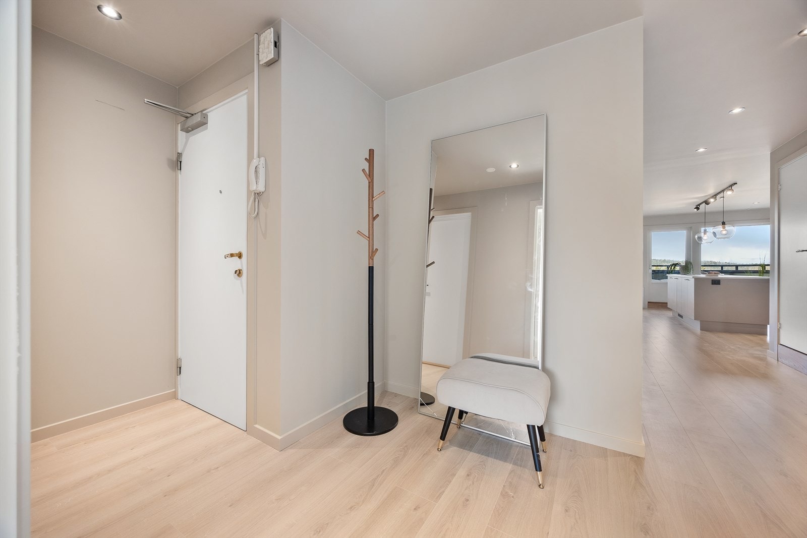 Leiligheten har en romslig entre med plass til oppheng av tøy og til å sette fra seg sko. Galleribilde