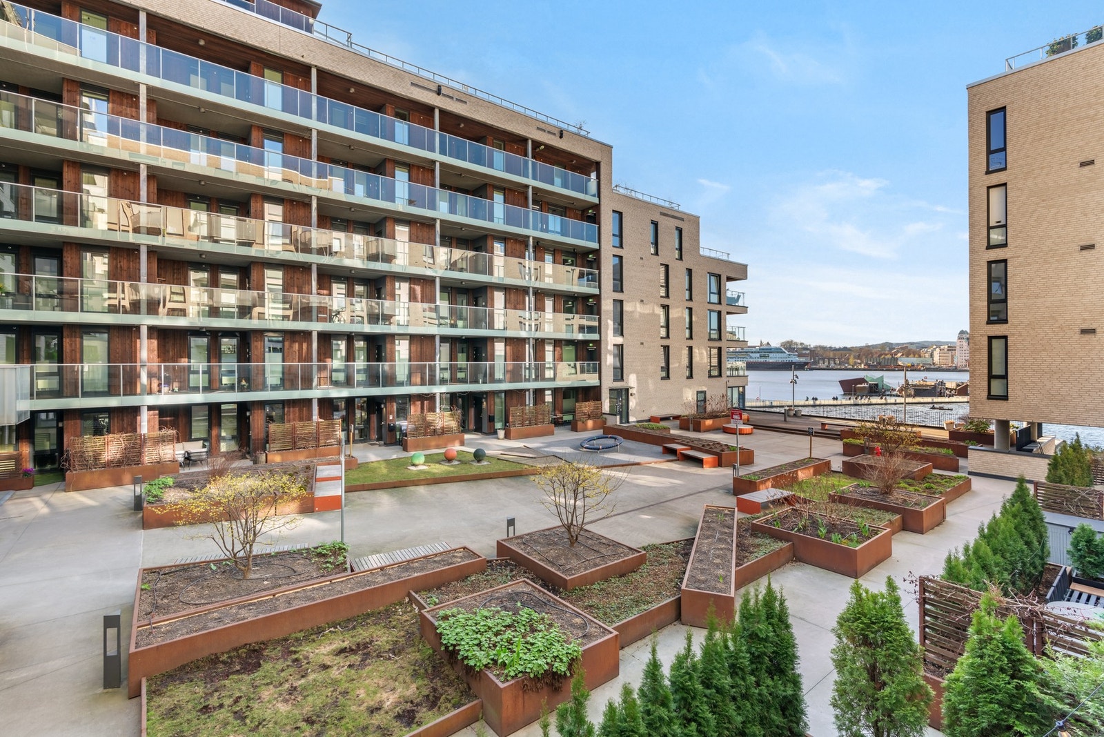 Fra balkongen er det utsyn til det hyggelige gårdsrommet og ut mot fjorden. Galleribilde