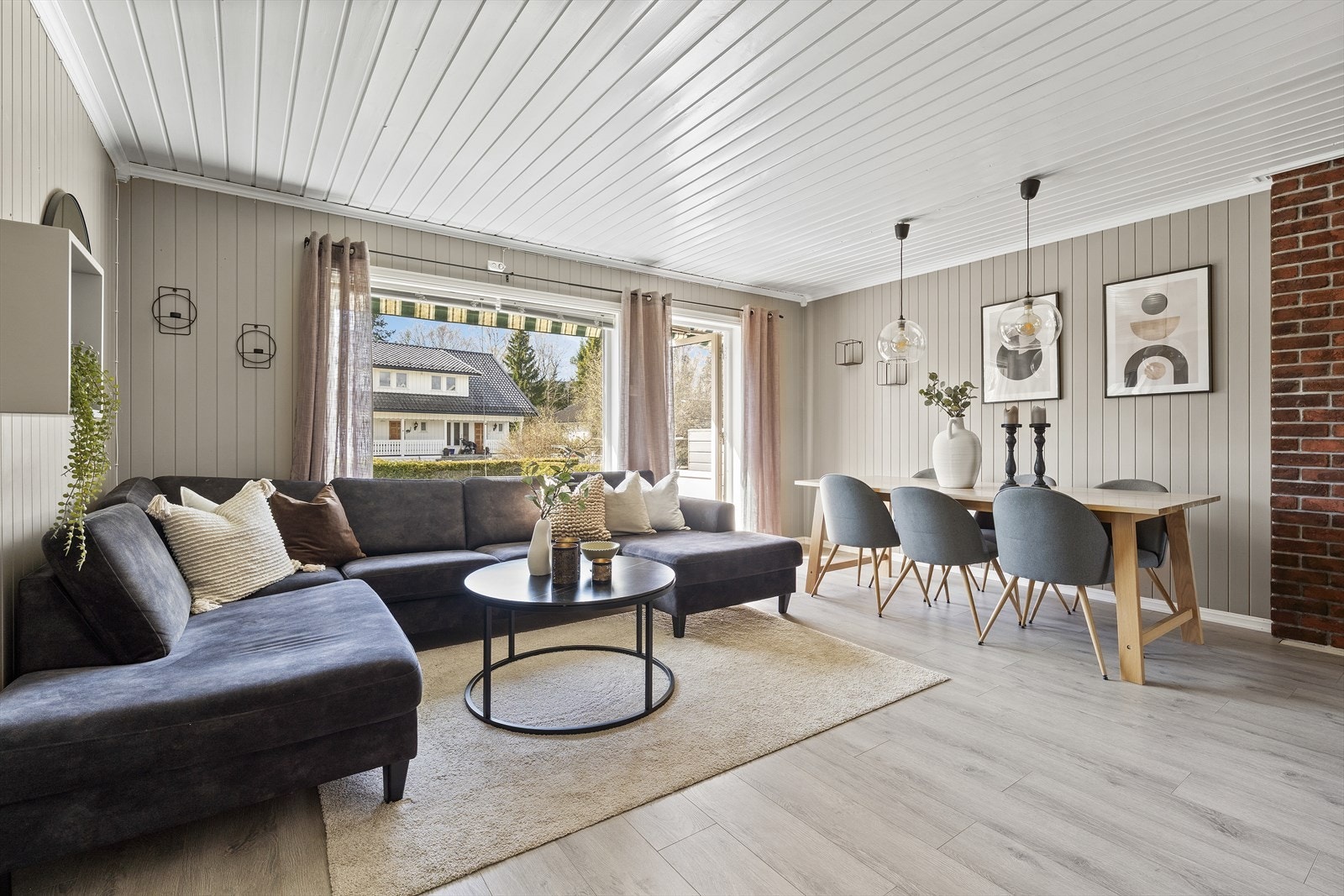 Lys stue som er malt i tidsriktige farger som gir rommet et moderne og og innbydende inntrykk. Utgang til platting/terrasse Galleribilde
