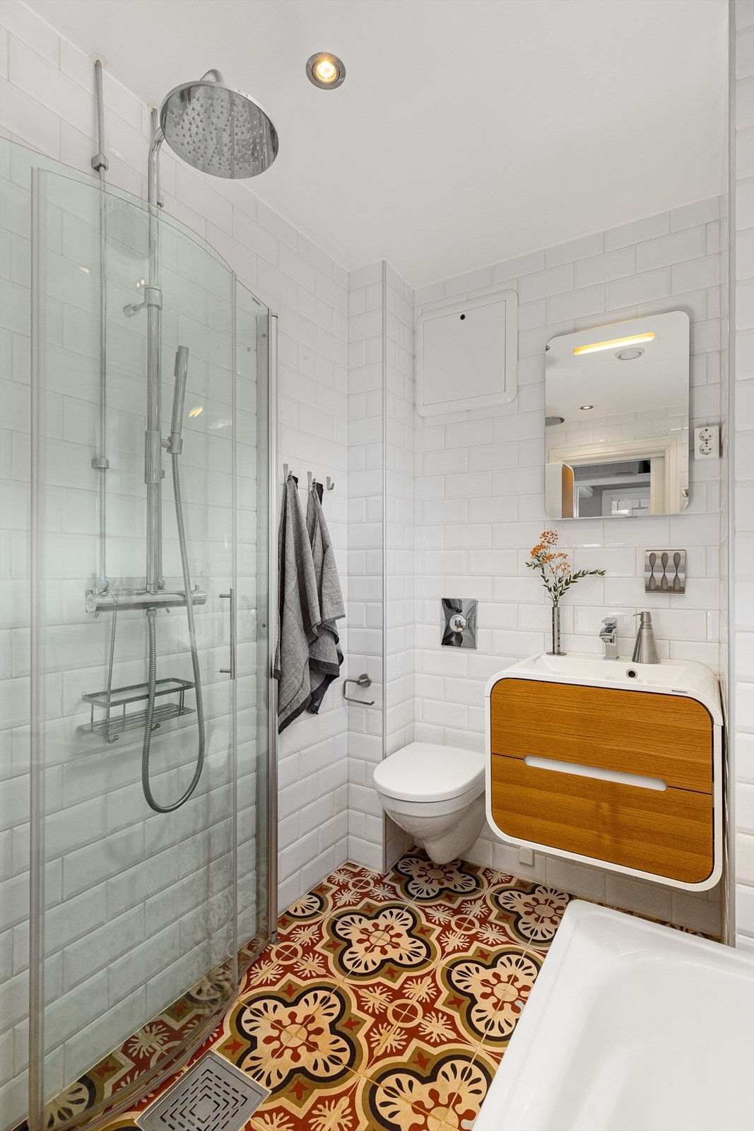 Badet har en innredning bestående av vegghengt klosett, servantinnredning, servant med ettgreps blandebatteri, dusjdører, dusjarmatur og badekar. Galleribilde