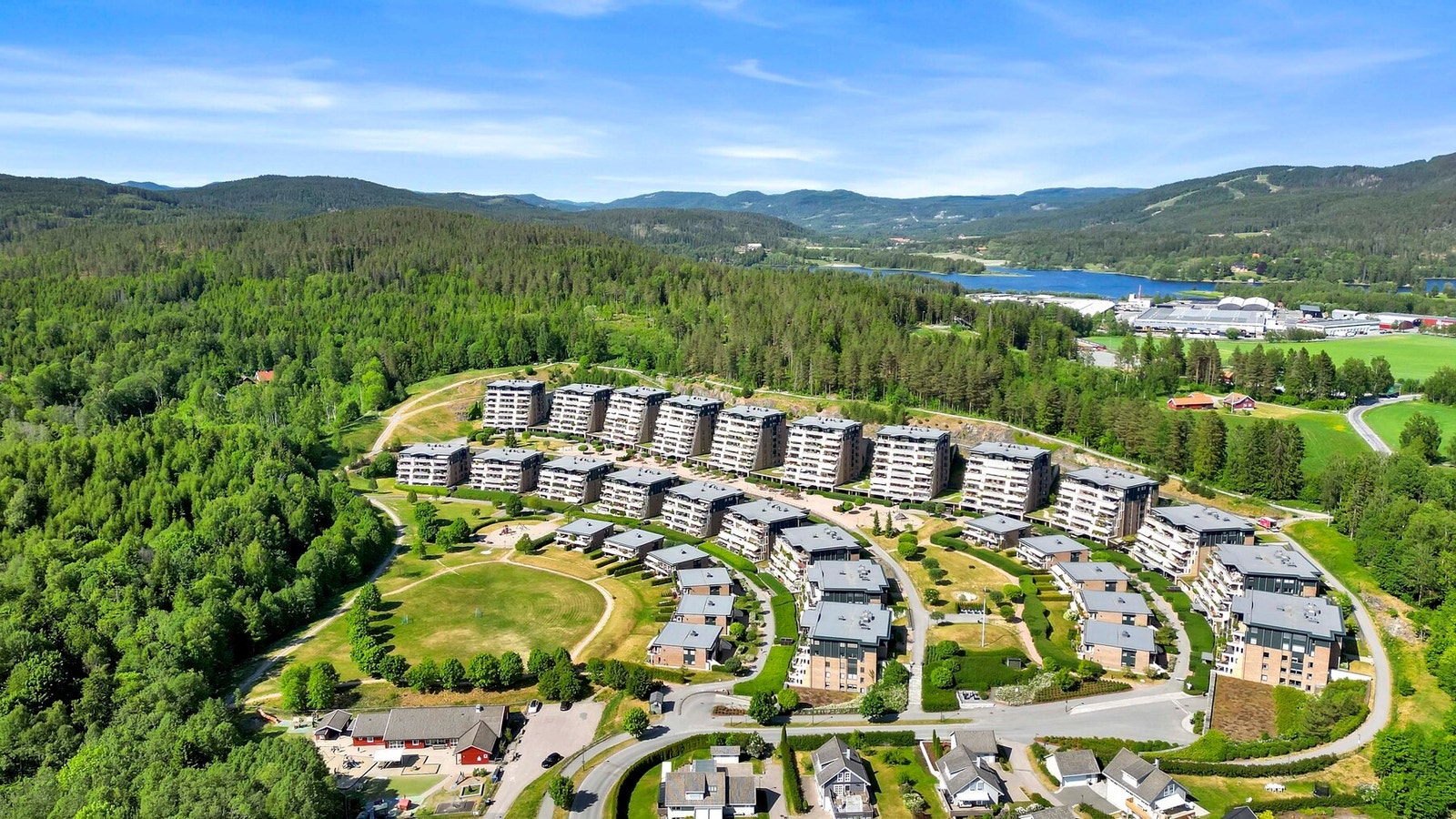 Fellesarealer med gressplener, prydbusker og bed. Stensatte og asfalterte gangveier og hyggelige lekeplasser. Galleribilde
