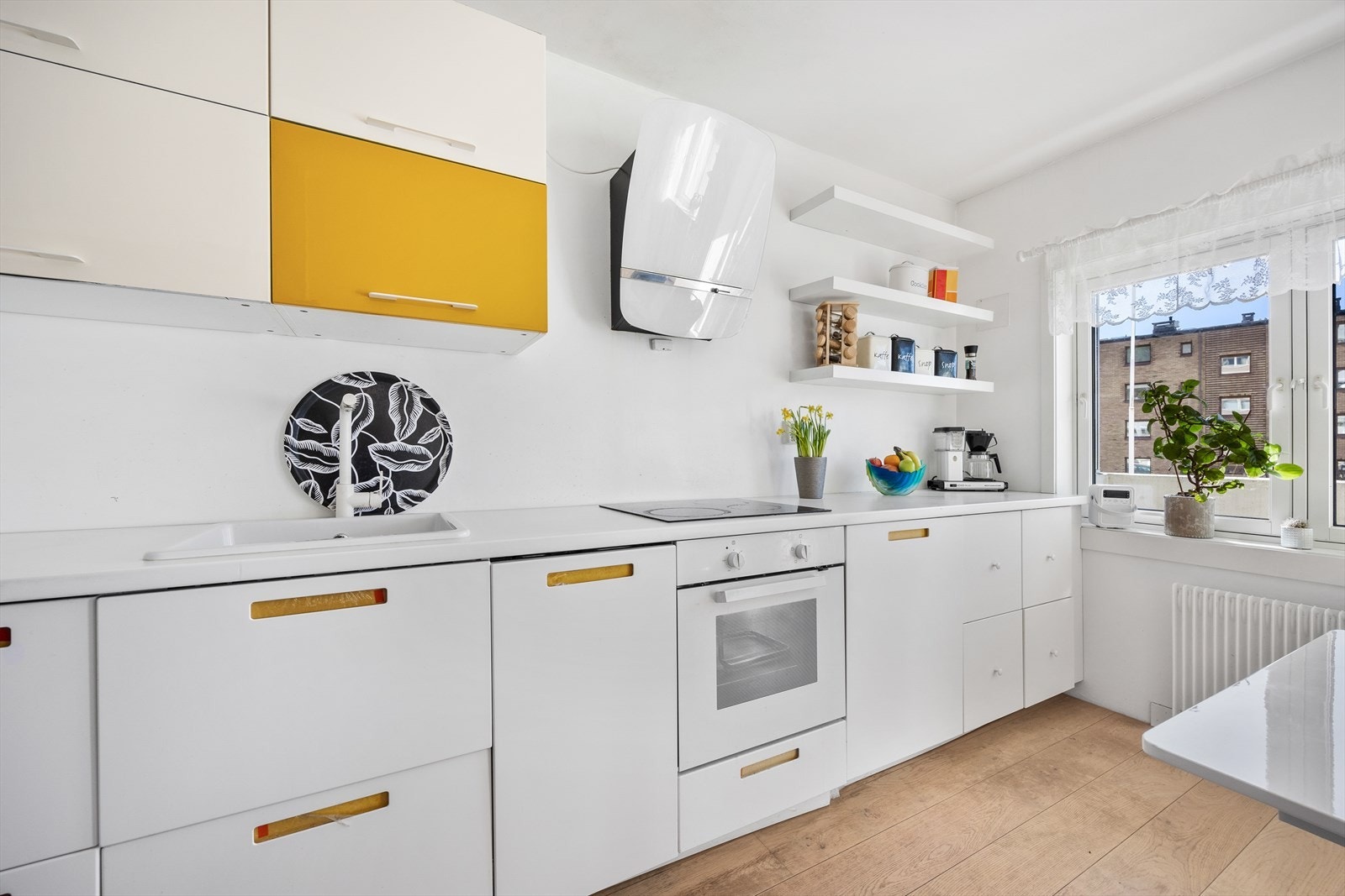 Kjøkken med moderne hvitevarer og stilfulle detaljer Galleribilde