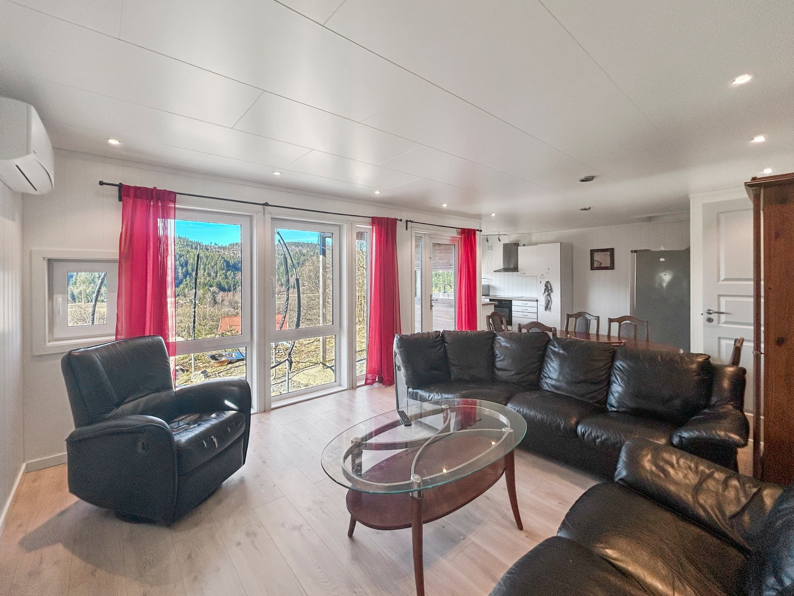 Romslig stue med plass til både sofa og spisebord. Her er det også utgang til fremsiden på huset der du har egen uteplass til disposisjon. Varmepumpe installert på vegg. Galleribilde